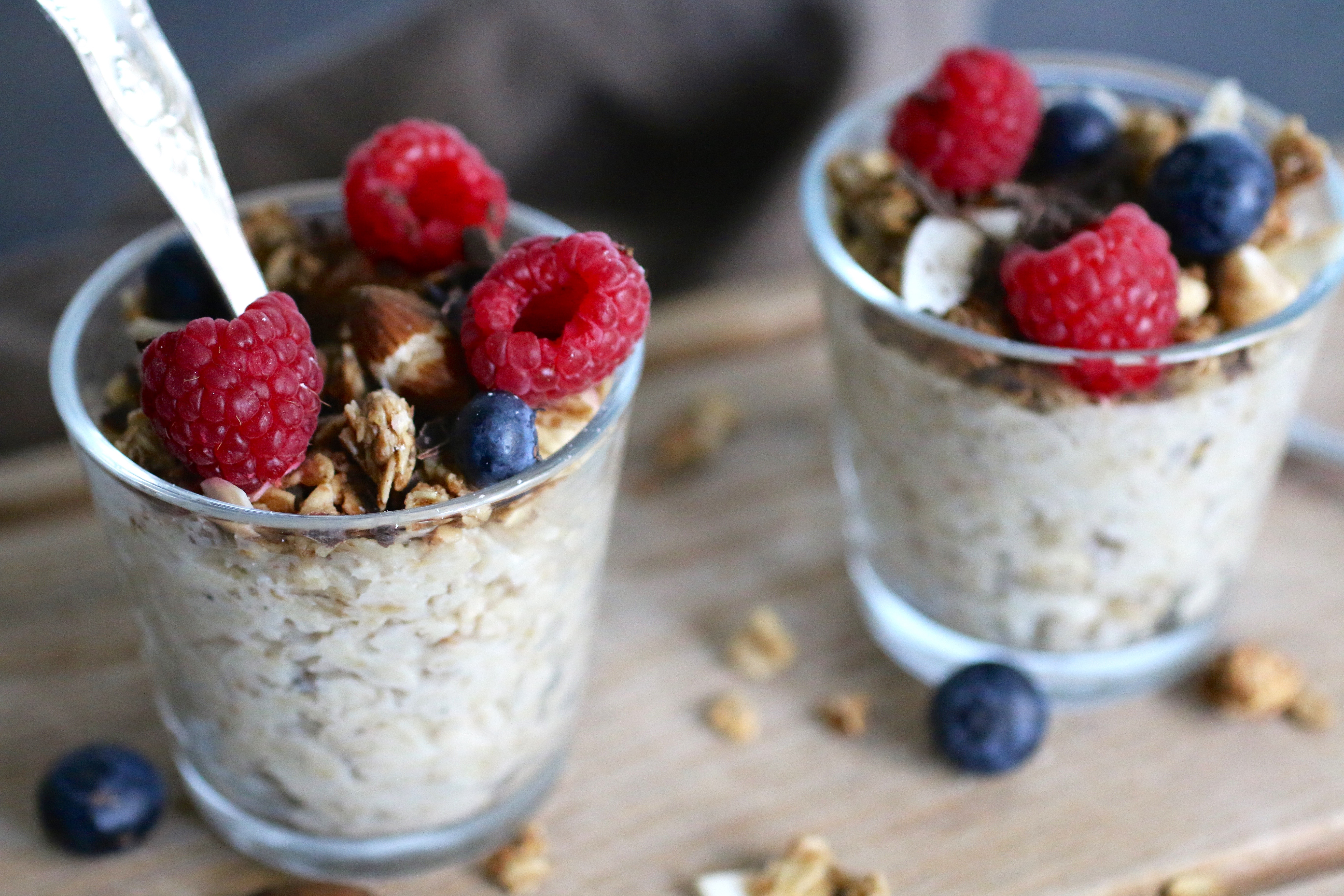 Overnight oats Två glas med overnight oats toppade med hallon och blåbär.