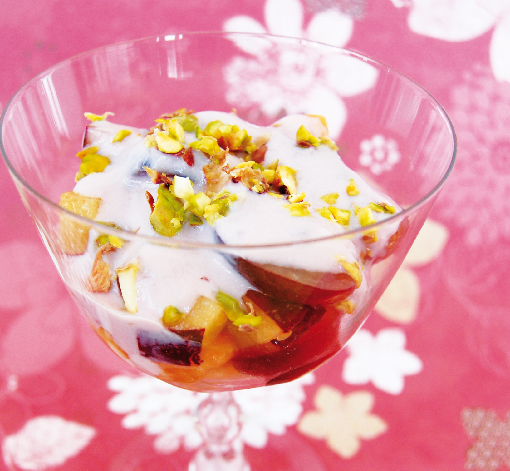 Fruktsallad med pistagenötter och vaniljyoghurt Fruktsallad med pistagenötter och vaniljyoghurt i en glasbägare.