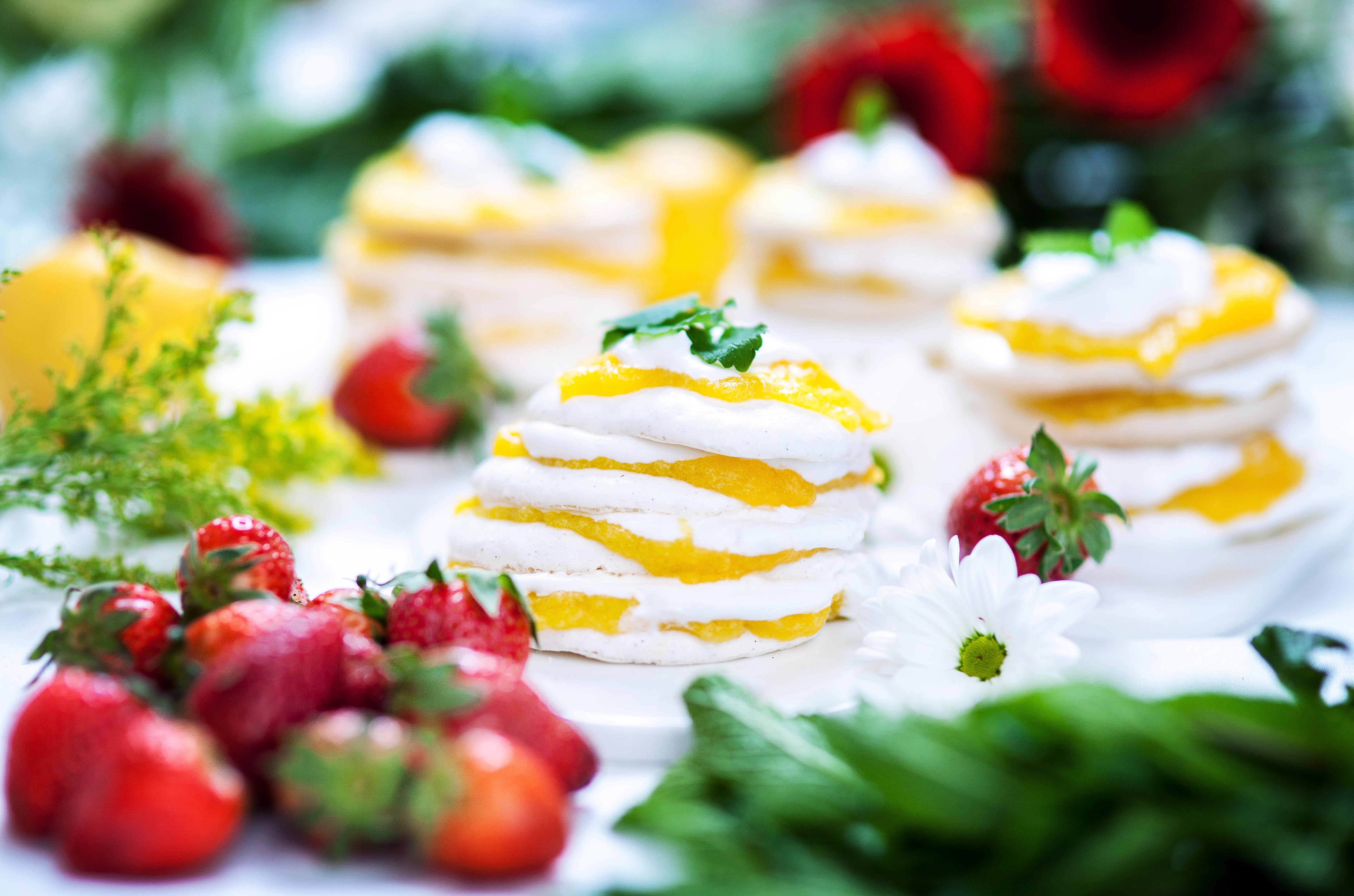 Gräddig marängtårta med mango curd Marängtårta med mango curd, dekorerad med jordgubbar och citronmeliss.