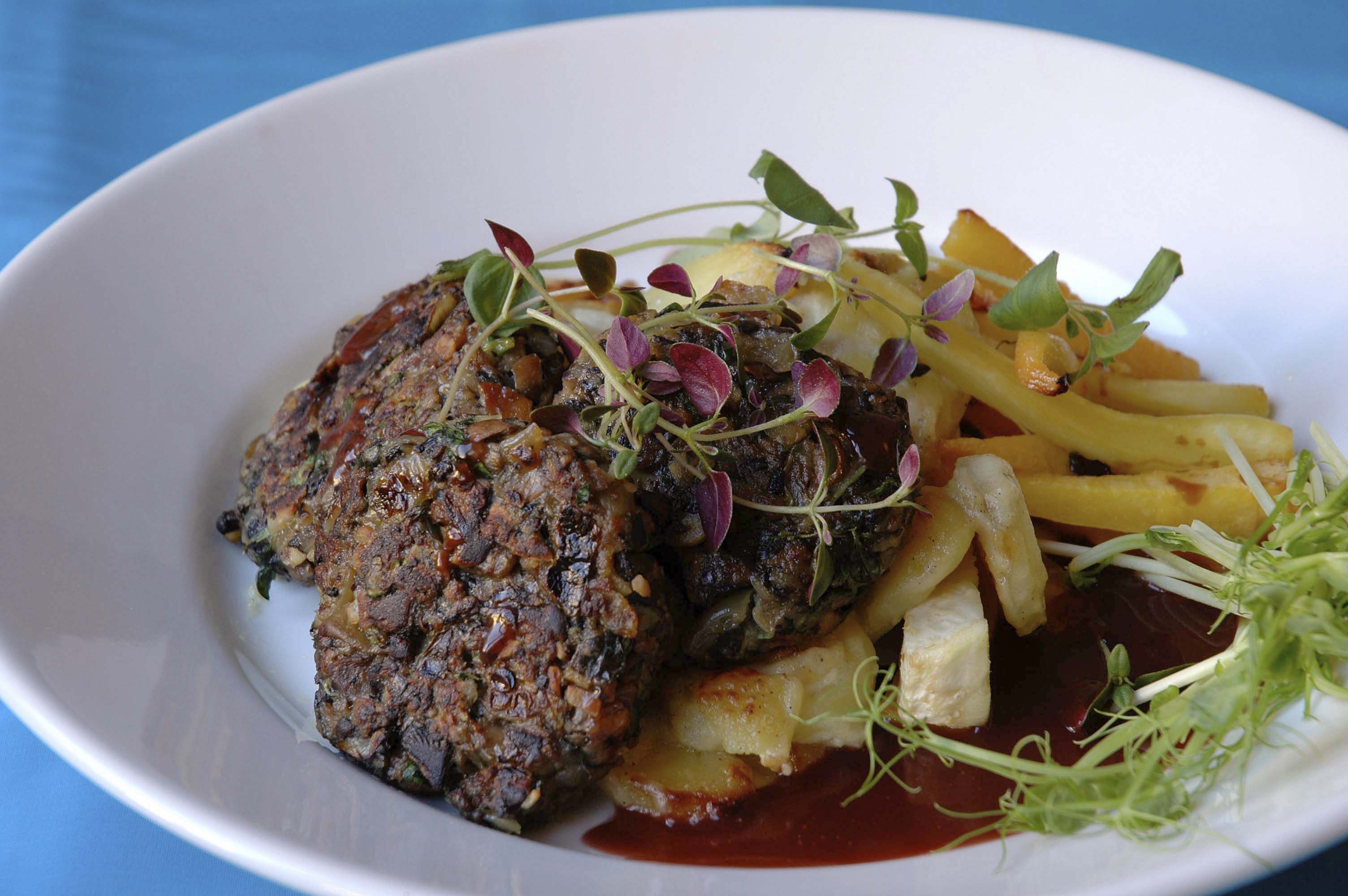 Svampbiffar Veganska svampbiffar med sås och potatis på en vit tallrik.