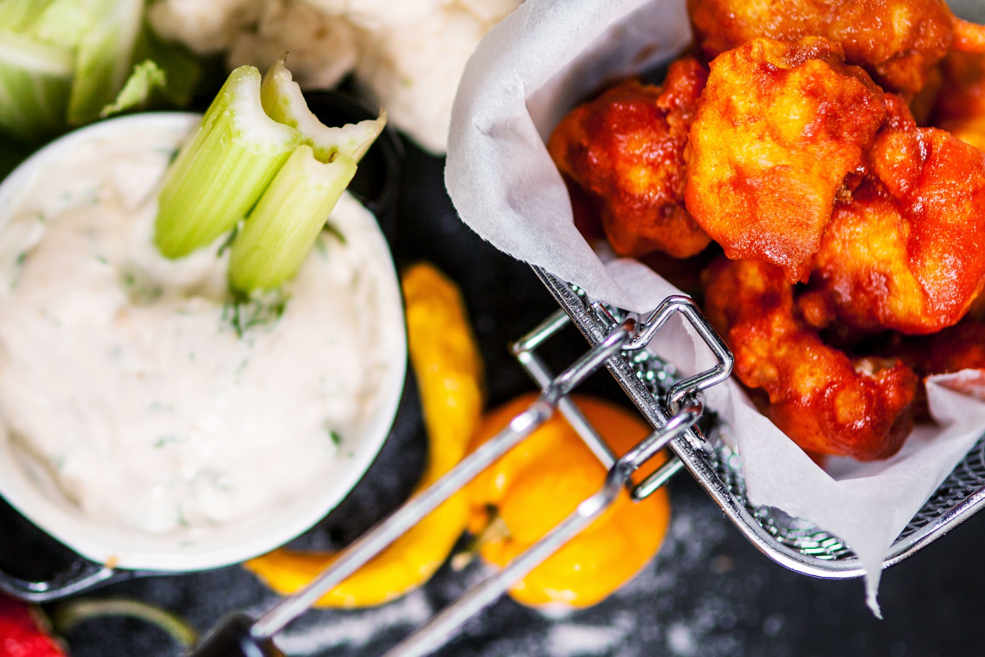Buffalo wings av blomkål Buffalo wings av blomkål i en frityrkorg, bredvid står en skål med blåmögelostsås
