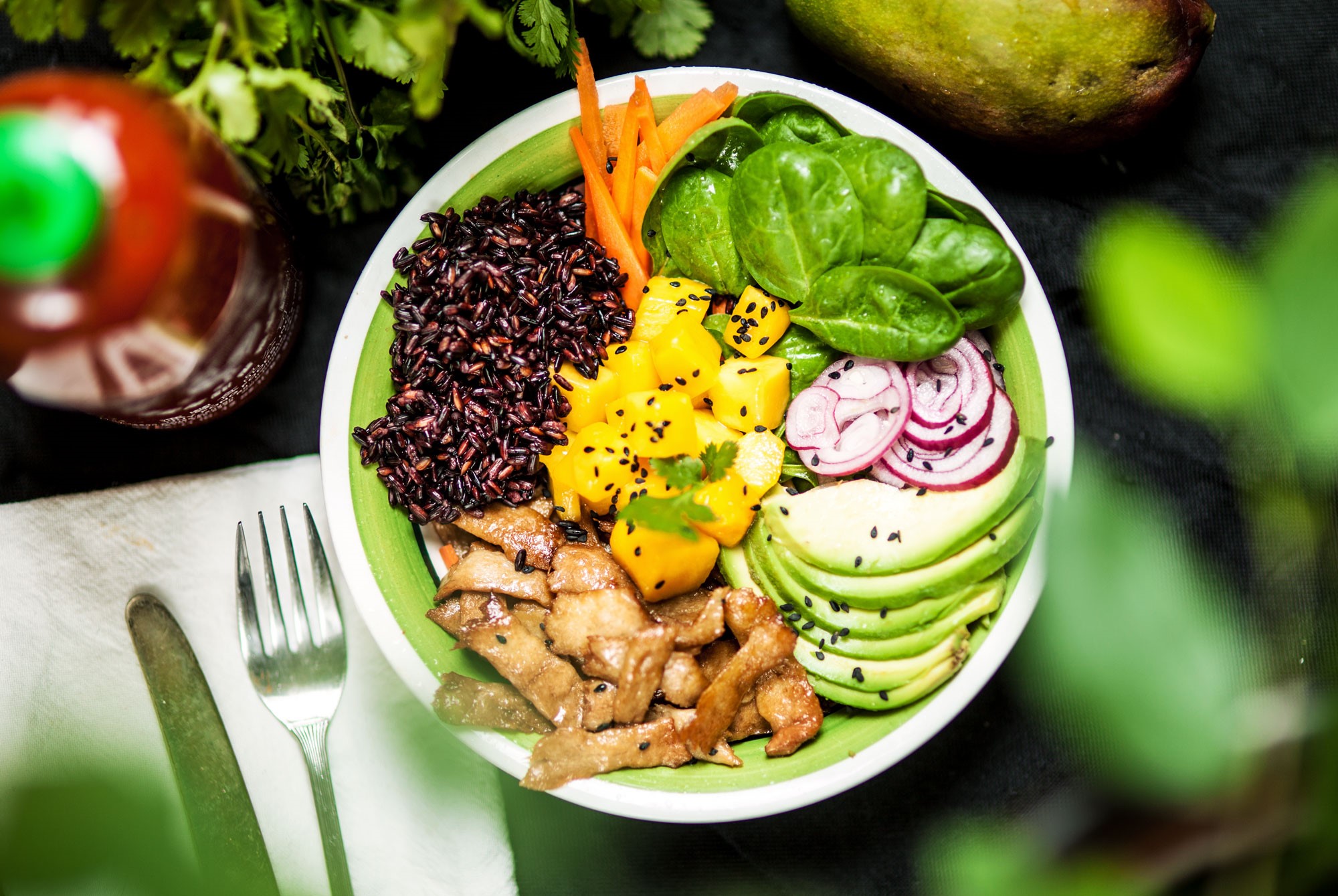 Poké bowl En pokébowl med babyspenat, mangobitar, vegobitar, svart ris och avokado.