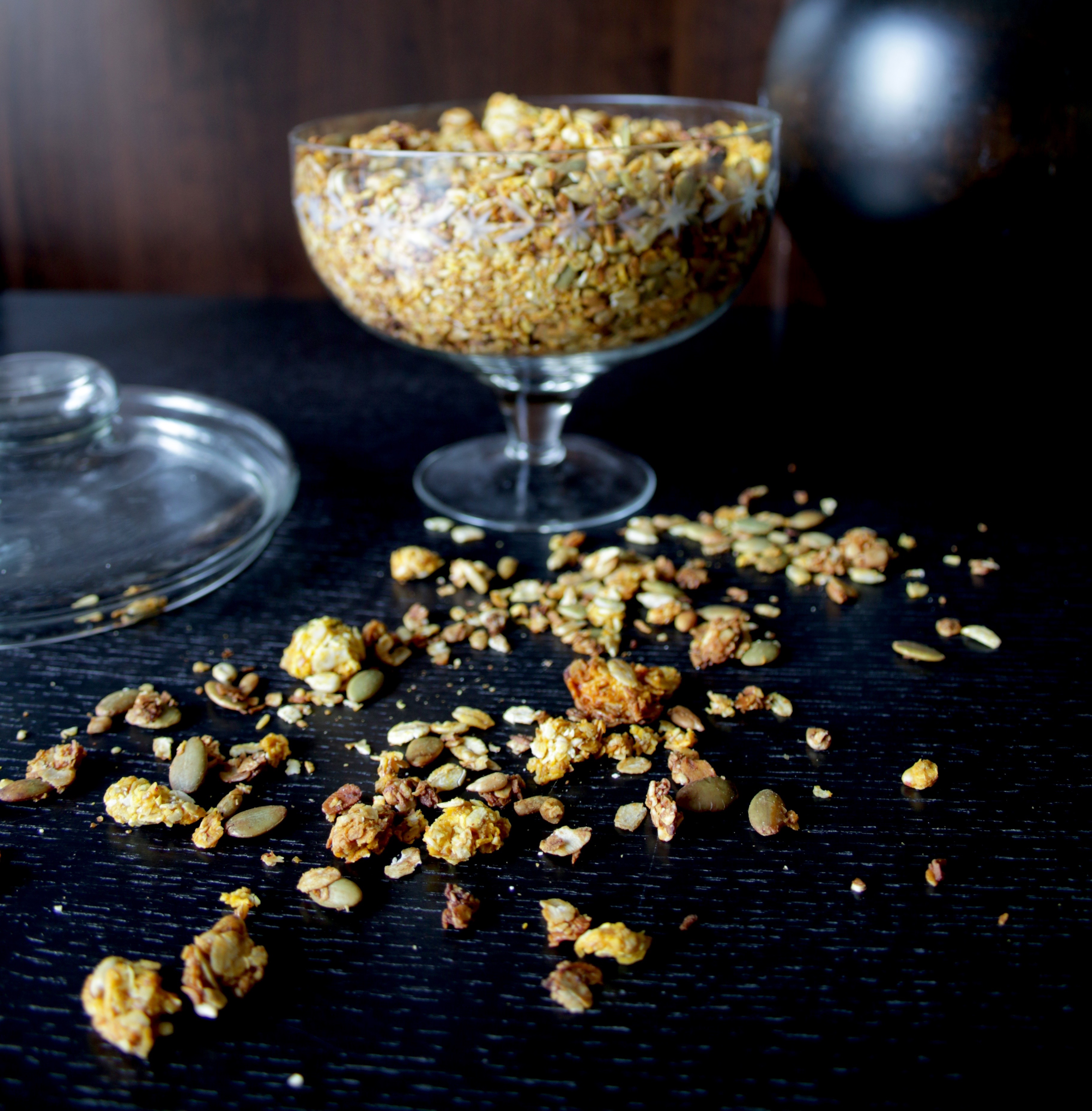 Julig saffransgranola Saffransgranola i en glasbägare på ett mörkt bord.