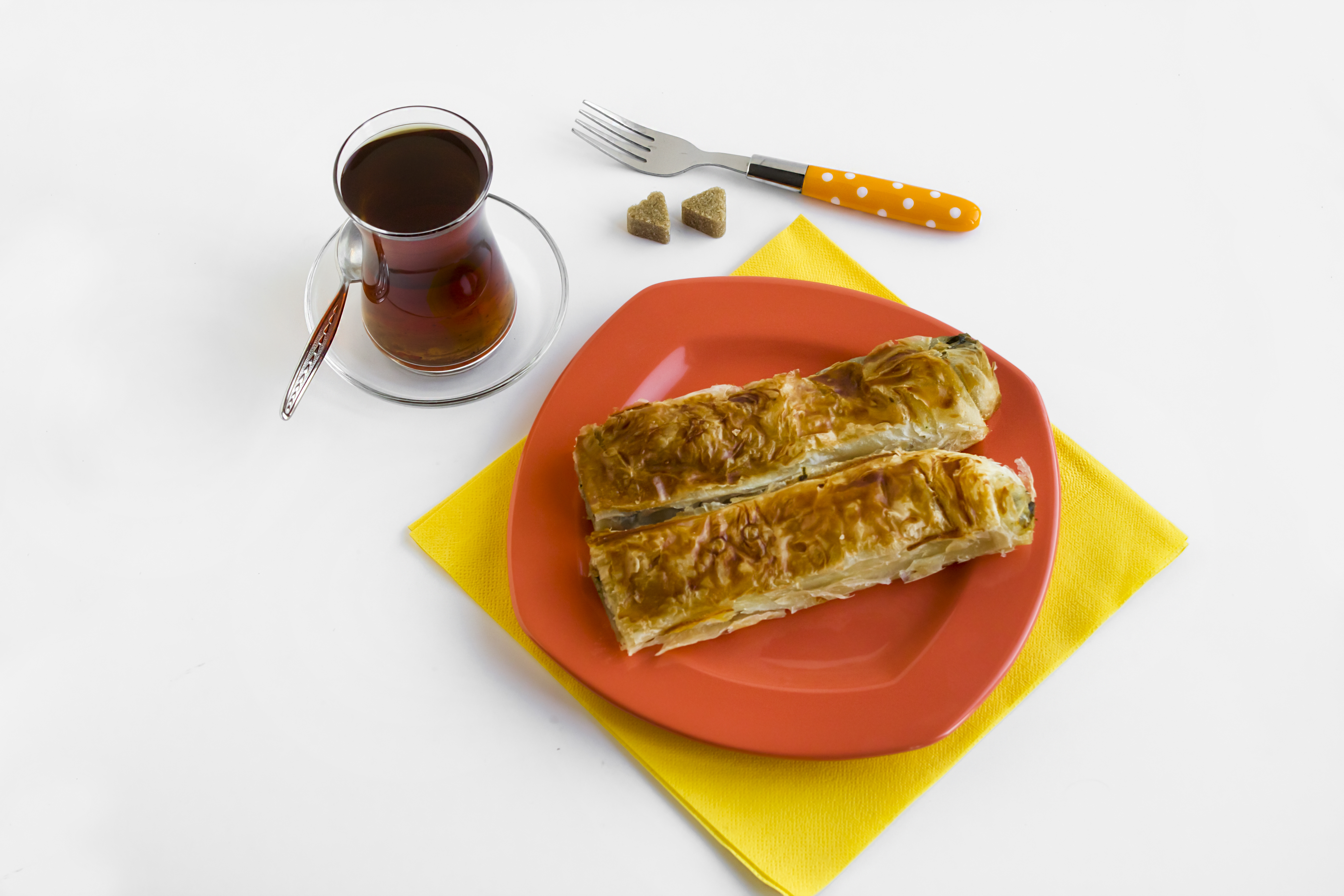 Vegansk börek vegan börek på en orange tallrik, bredvid står ett glas med te