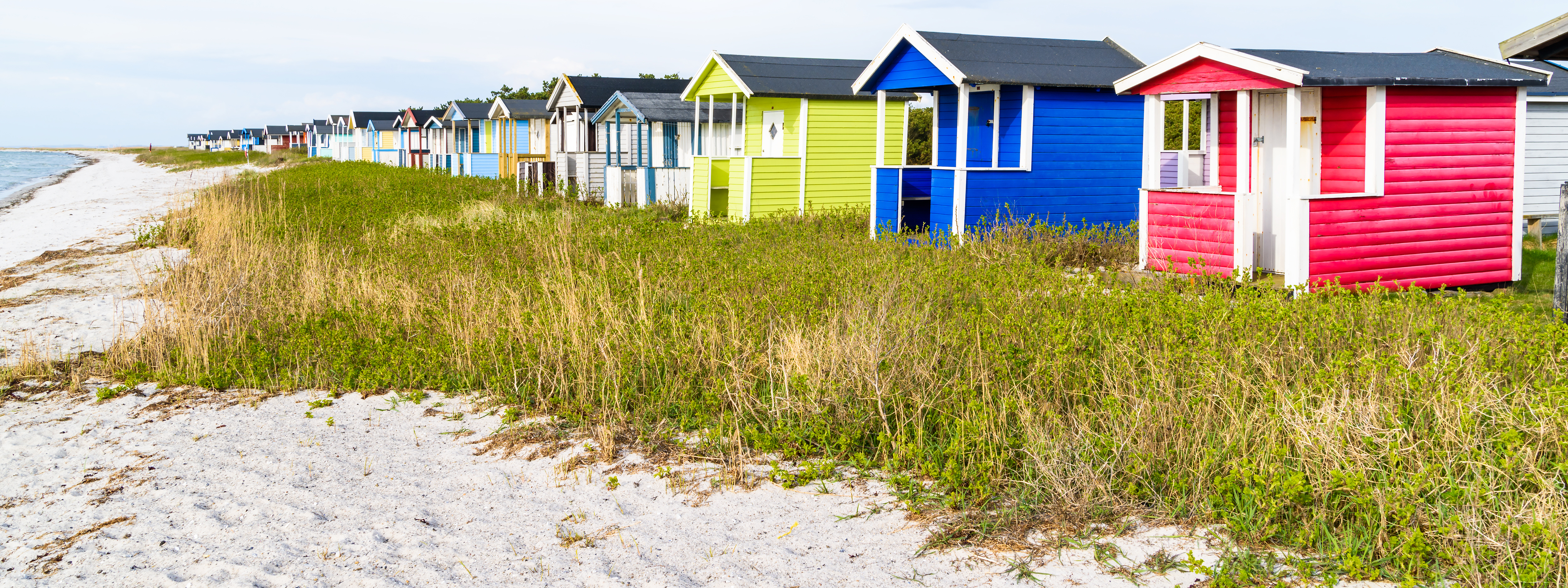 Bild på små färgglada hus i Skånevid stranden