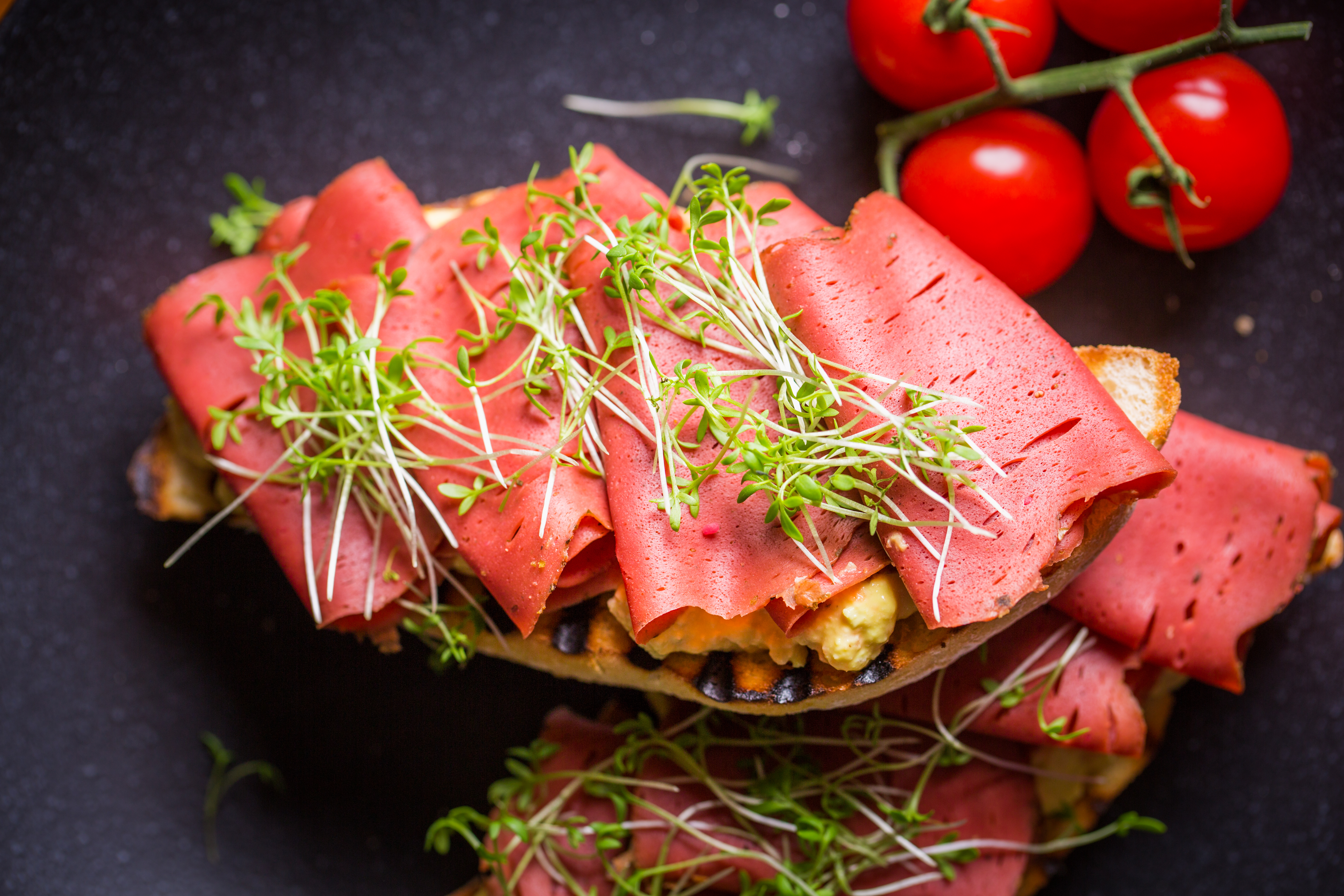 Shutterstock - Av Die Wiener Lichtbildmanufaktur Vegansk skinka på en macka toppad med en gröna blad