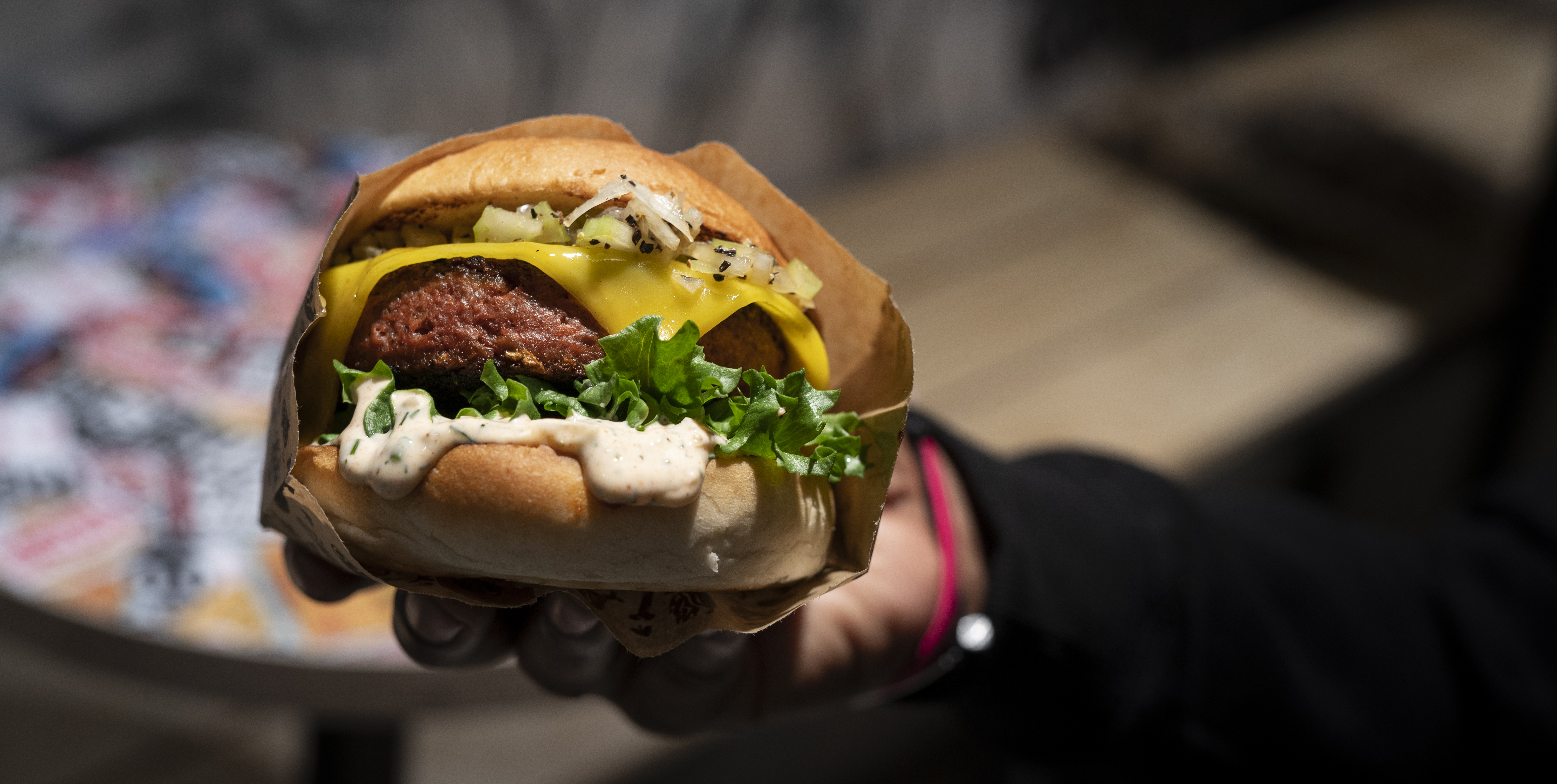 Person håller upp en vegansk burgare