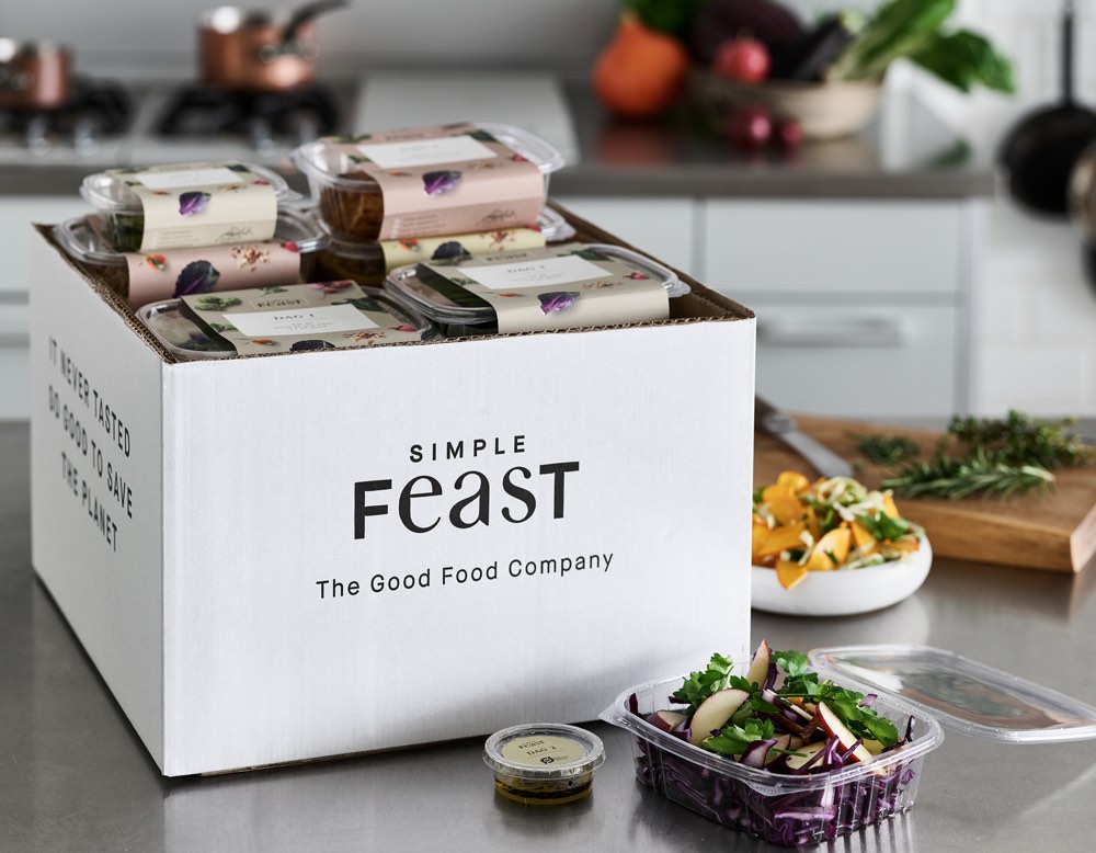 En box fylld av växtbaserade rätter från Simple Feast på en köksbänk.