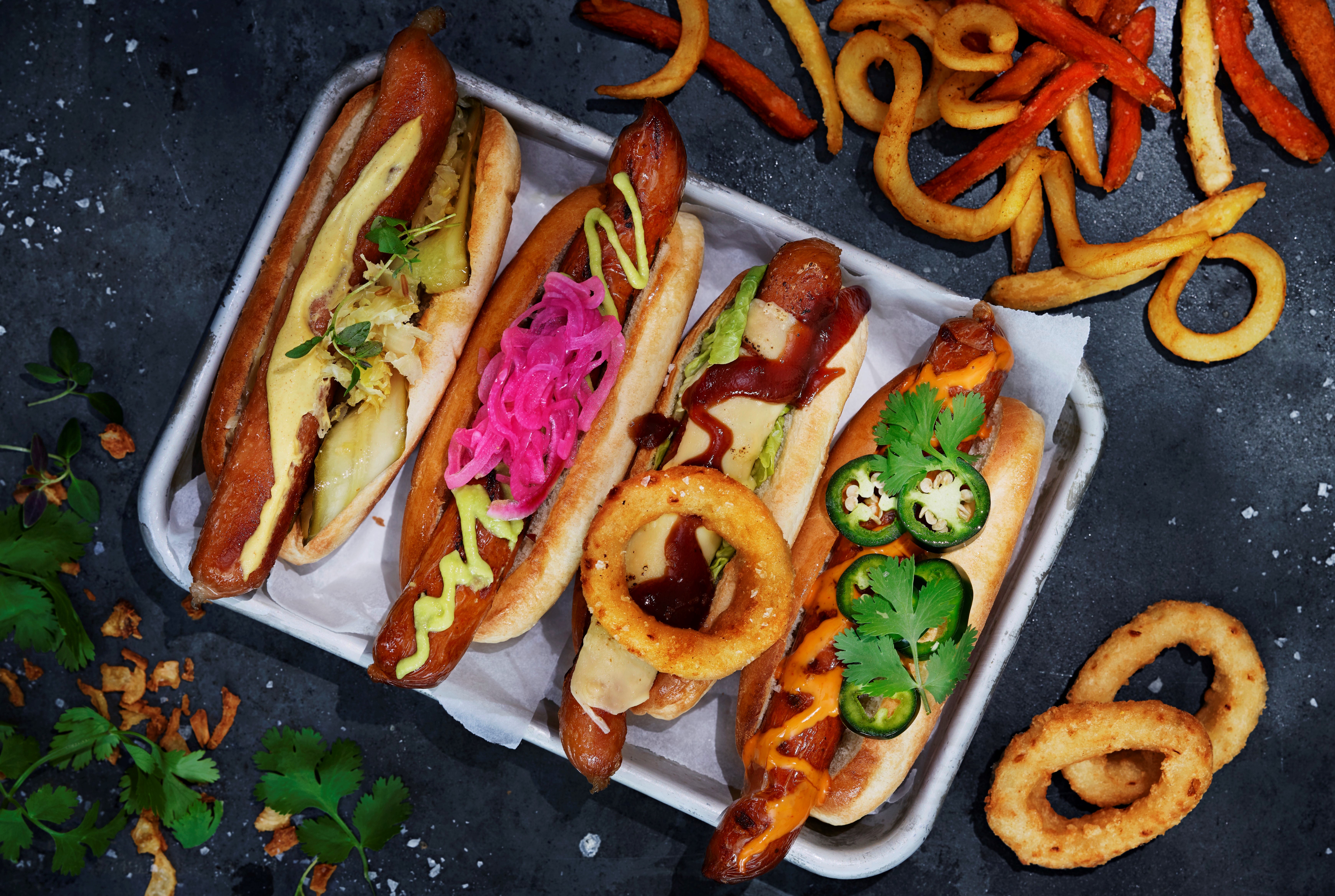 Flera veganska korvar med bröd på en bricka
