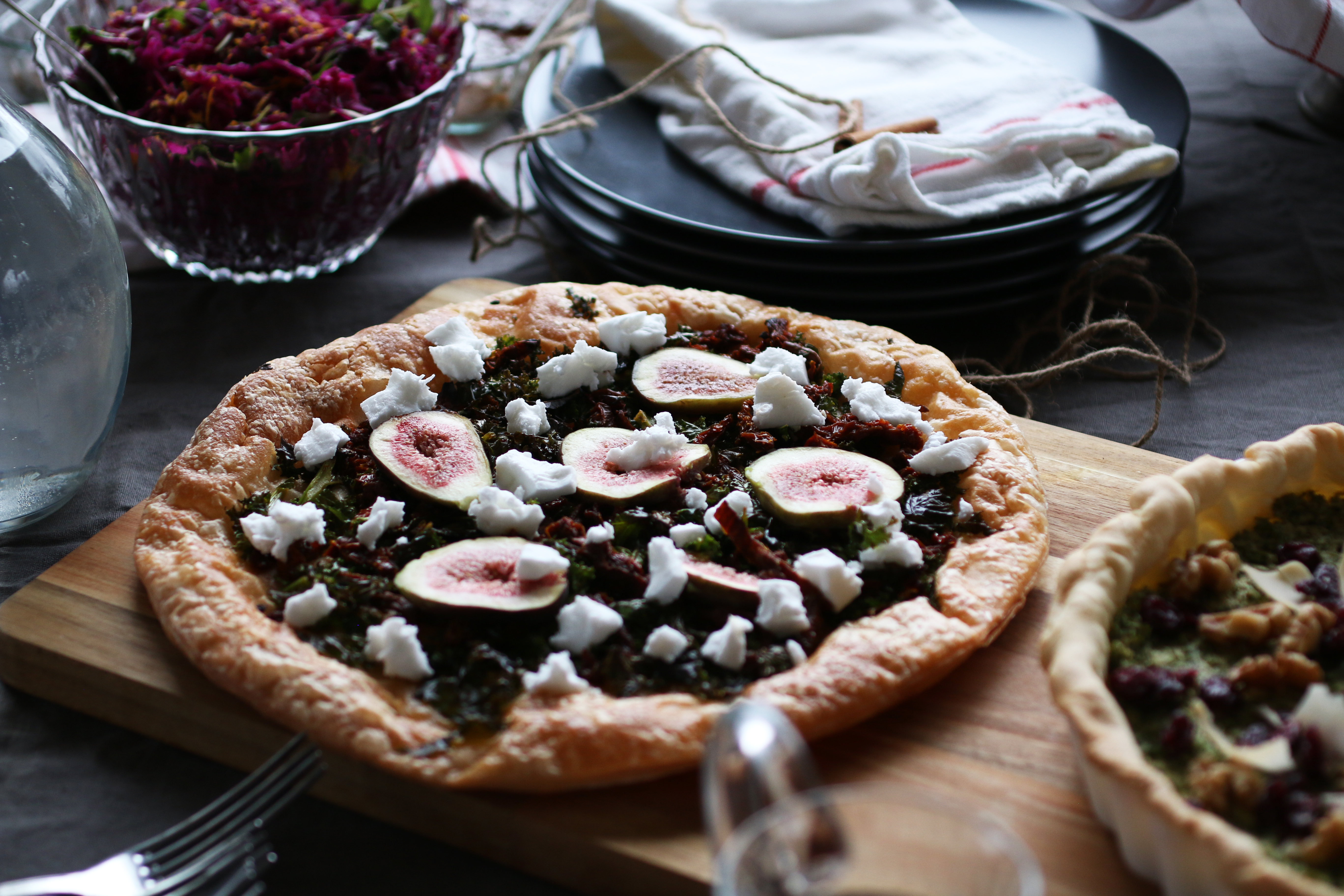 Smördegspaj med grönkål, soltorkade tomater, fikon och vegansk feta på en bräda