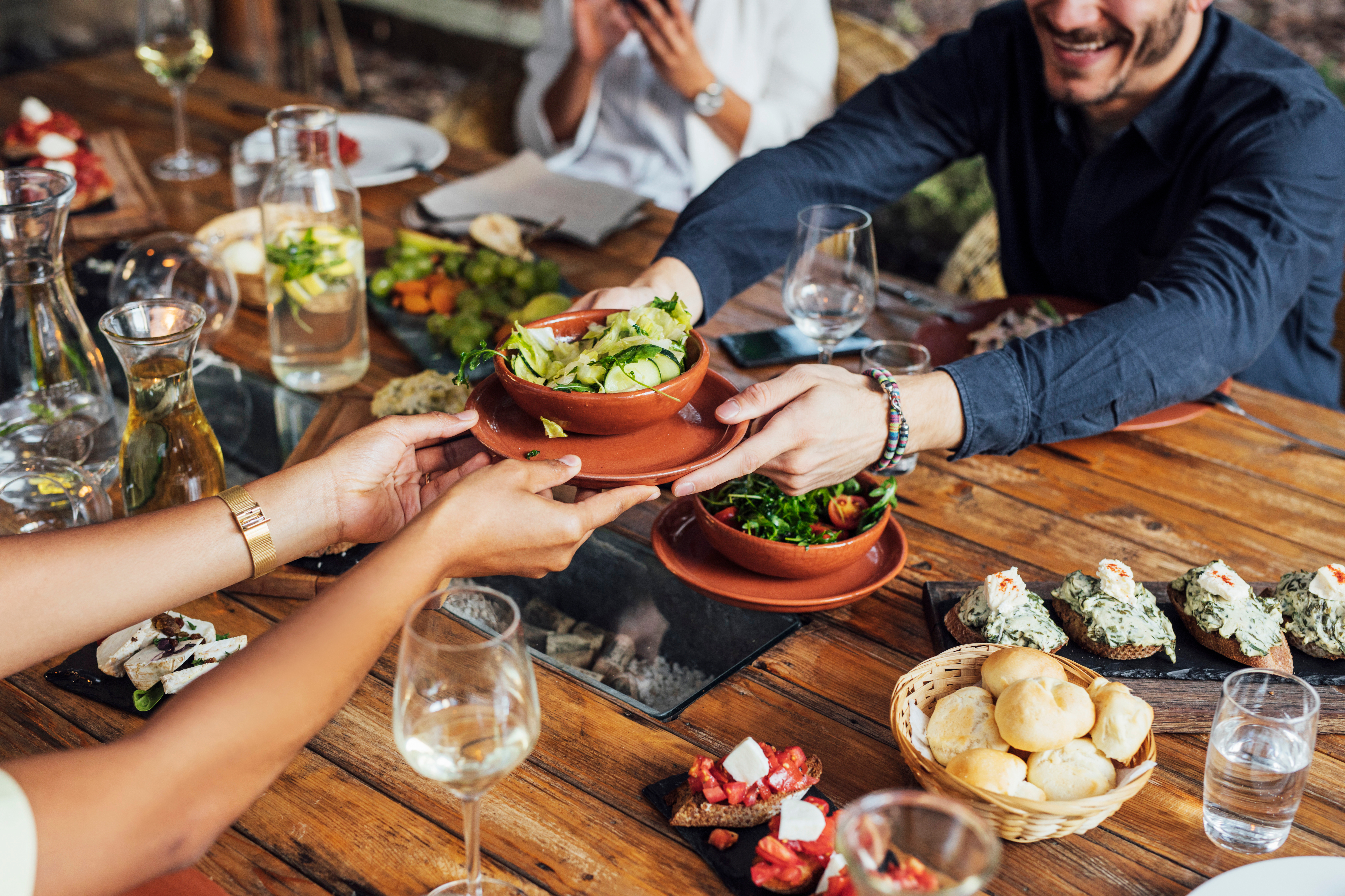 Flera personer runt ett bord delar på veganska rätter