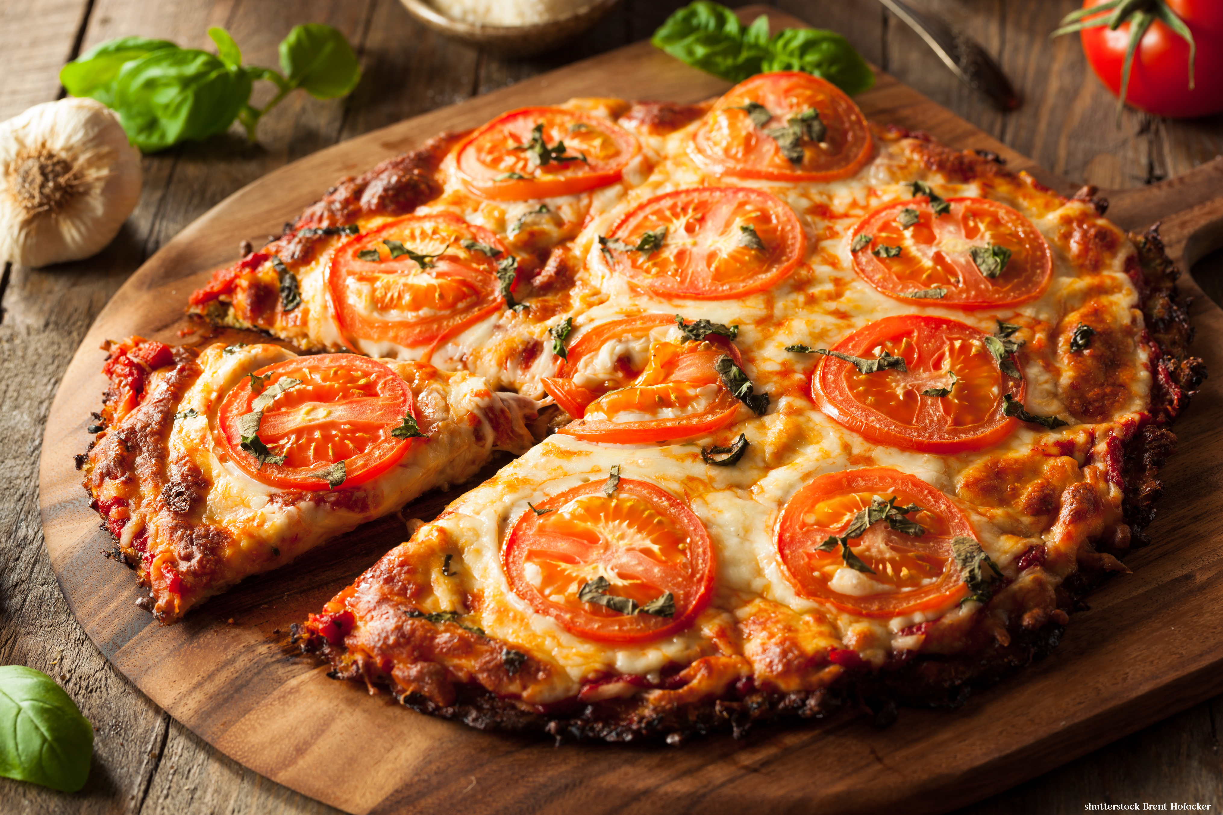 Vegansk pizza på rund träbräda
