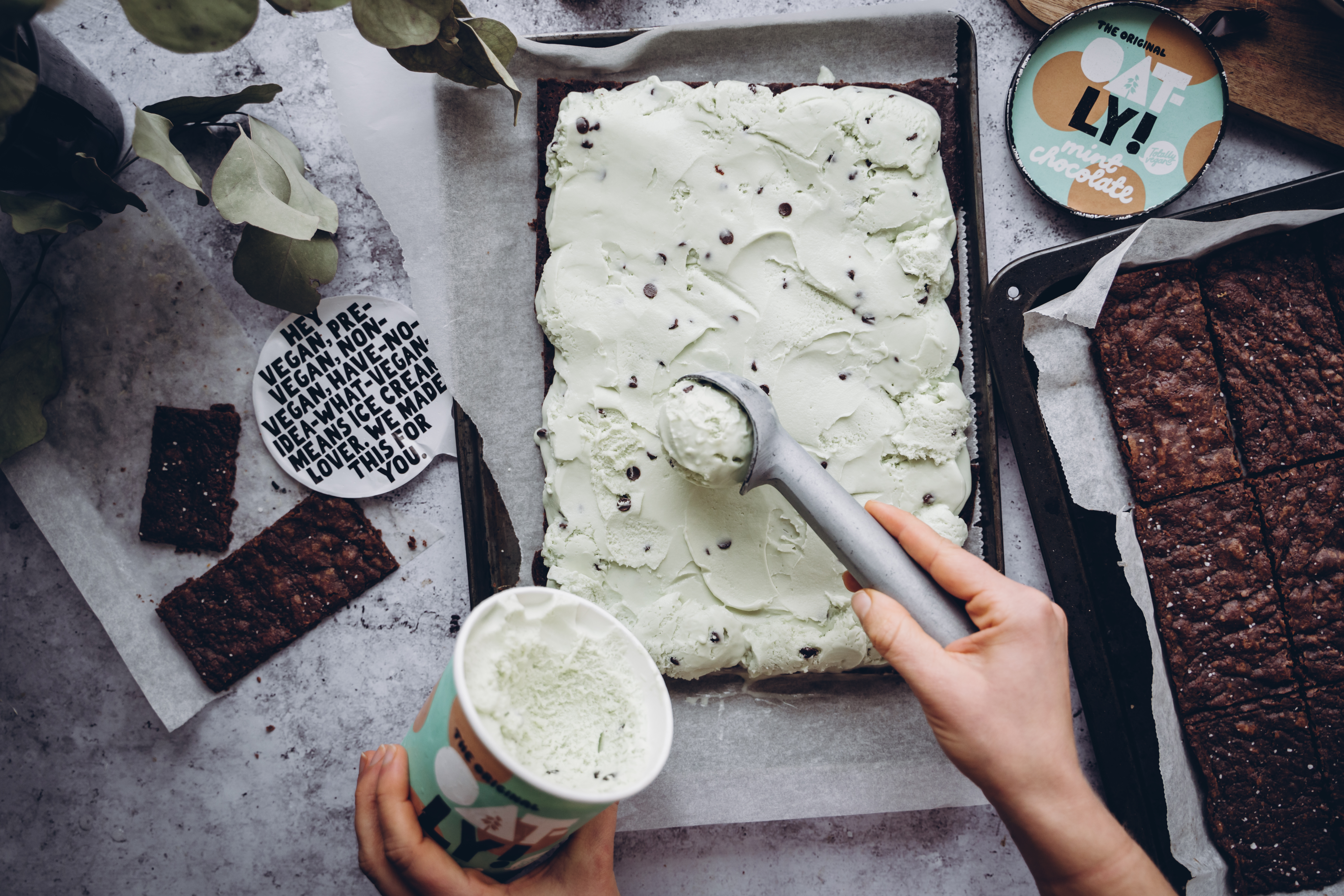 Produktfoto: Oatly Vegansk mintchoklad glass skopas och läggs på en brownie i en långpanna.
