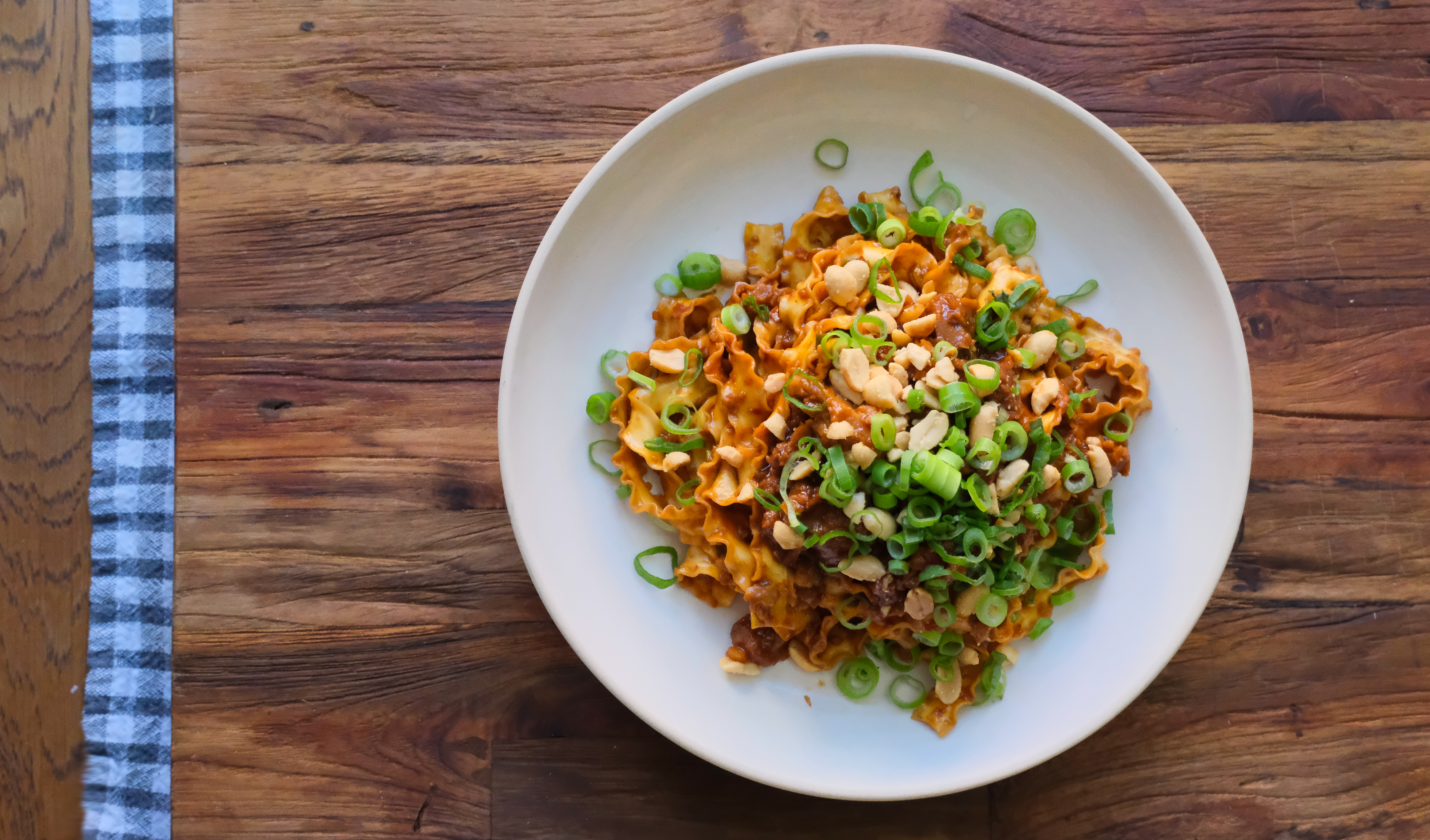 Produktfoto: Edgy Veggie Veganska nudlar uppdukad på en vitt tallrik på ett träbord.
