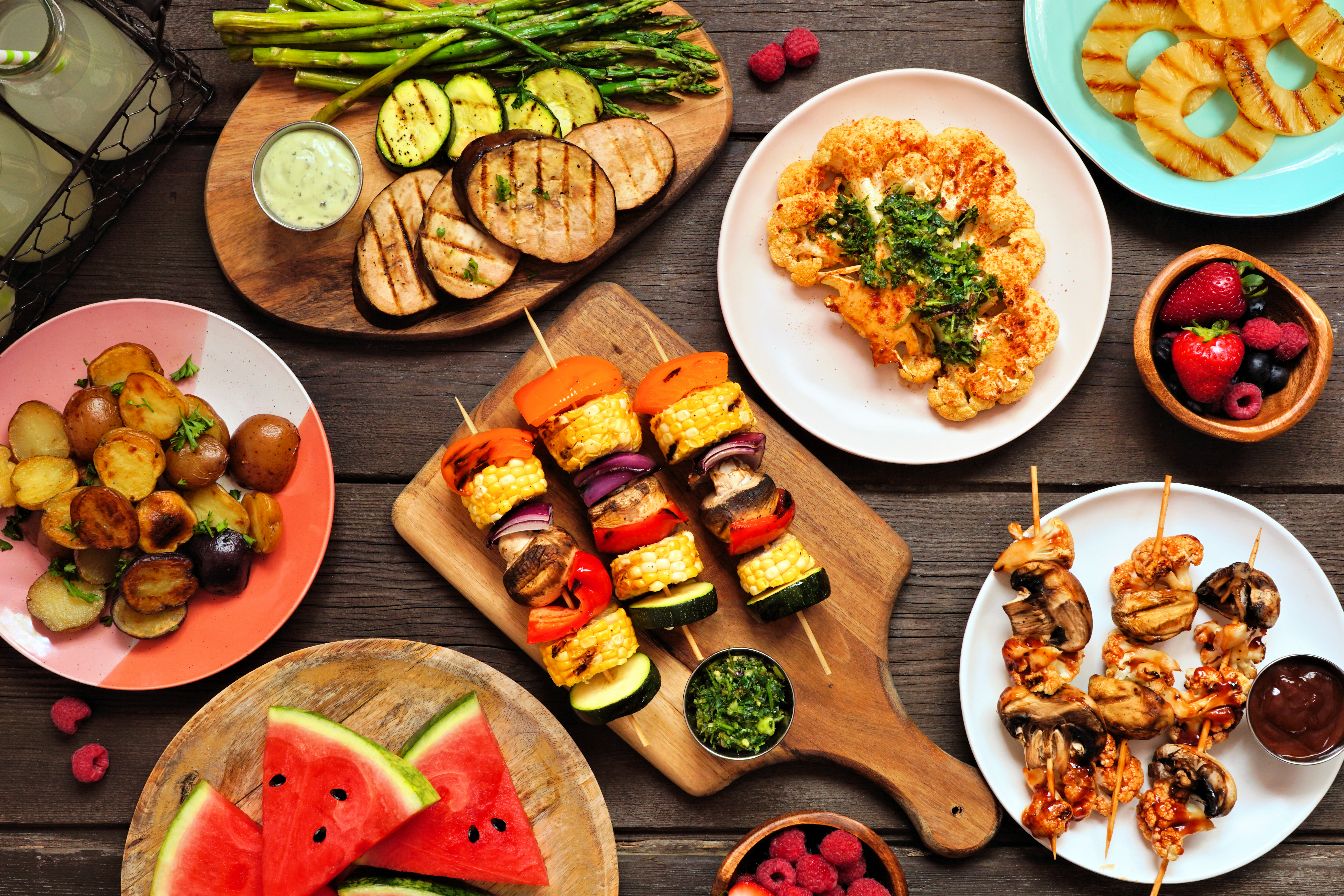 Foto: JeniFoto/Shutterstock Växtbaserad grillbuffe med frukt och grönsaker mot ett mörkt träbord.