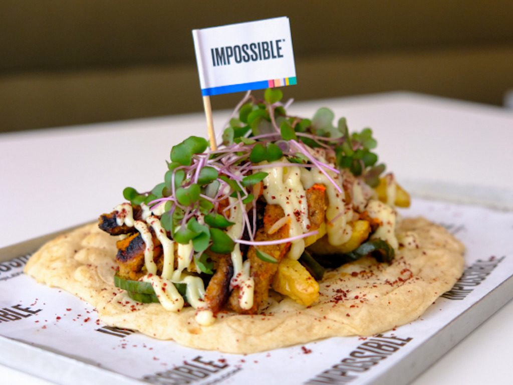 Produktfoto: Impossible Foods En tortilla med veganska nuggets och grönsaker på serverad på en bricka.