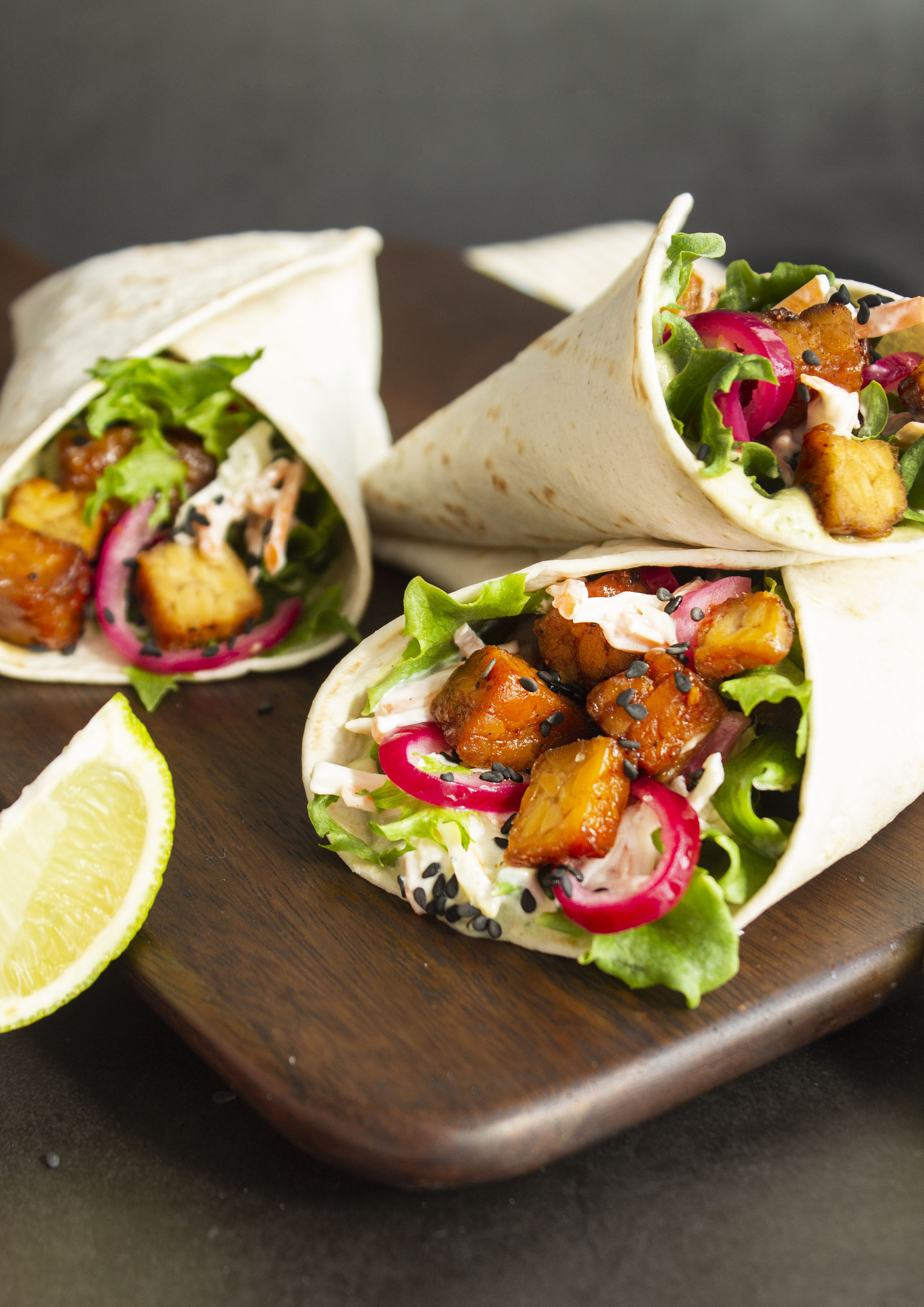 Produktfoto: Yipin tre veganska wraps uppstaplade på en skärbräda i trä