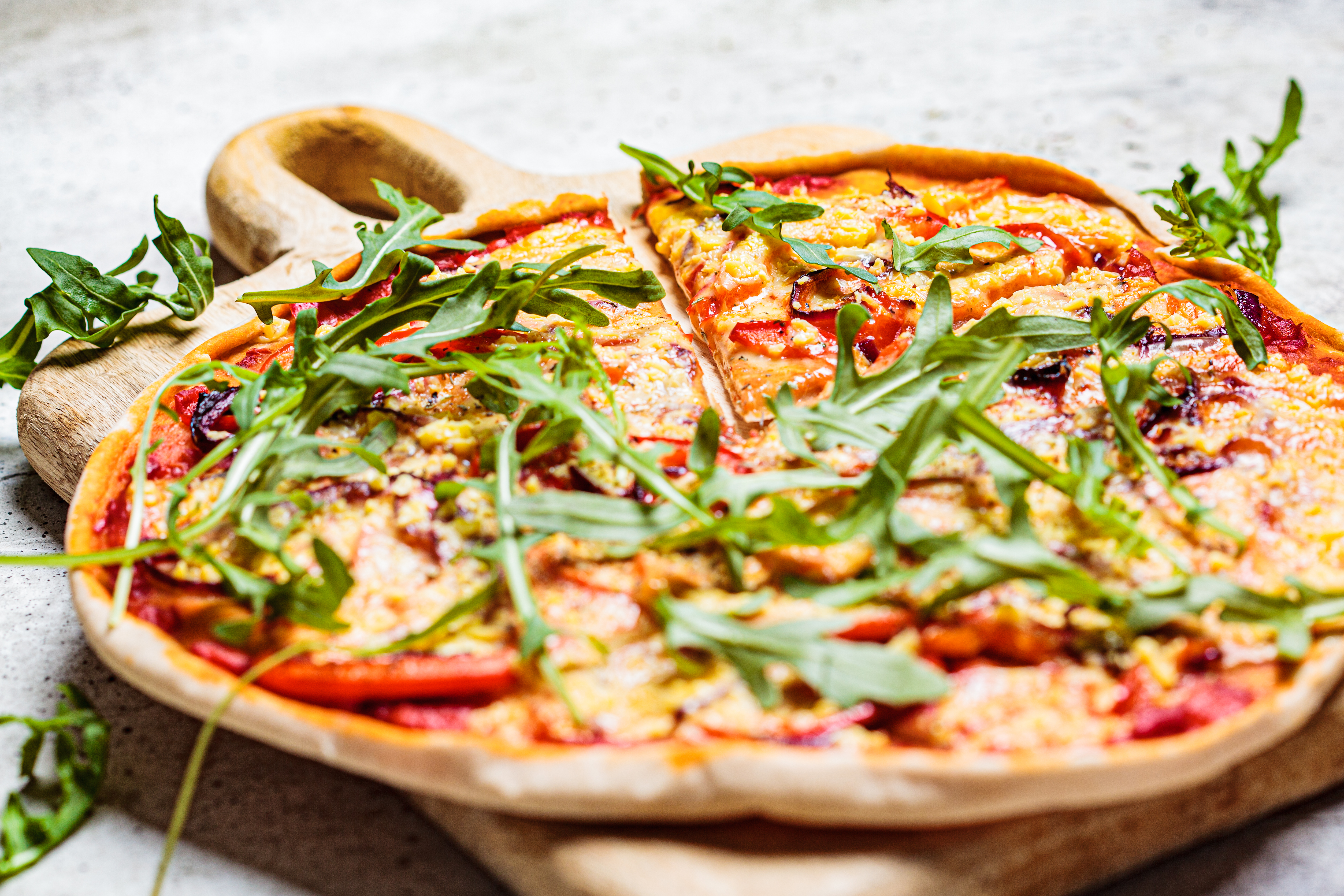Foto: Nina Firsova/Shutterstock Vegan pizza with tomato sauce, pepper, vegan cheese and arugula. Healthy vegan food concept.