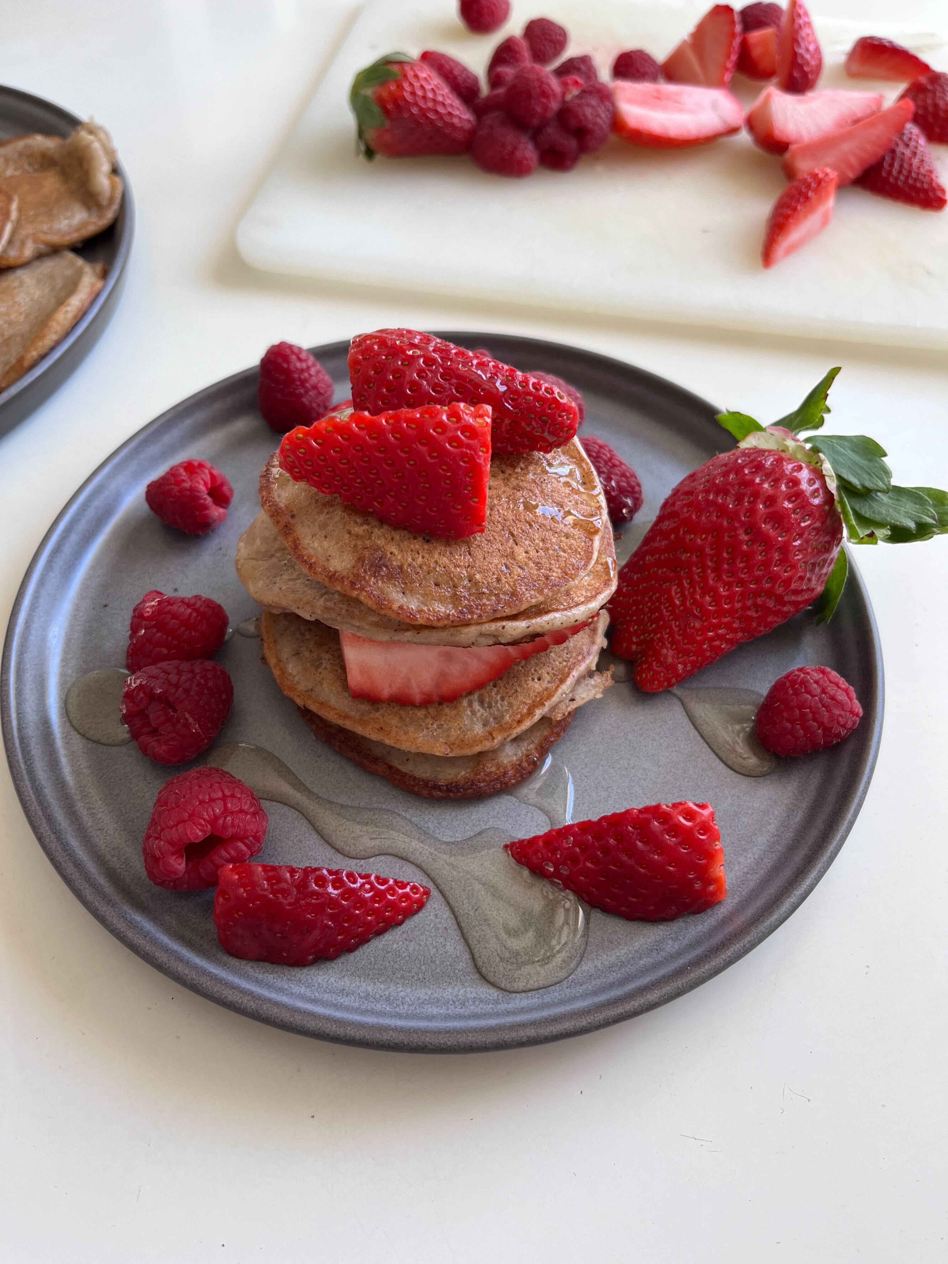 Foto: Rebecca Johansson Amerikanska pannkakor staplade på ett grått fat med jordgubbar och hallon