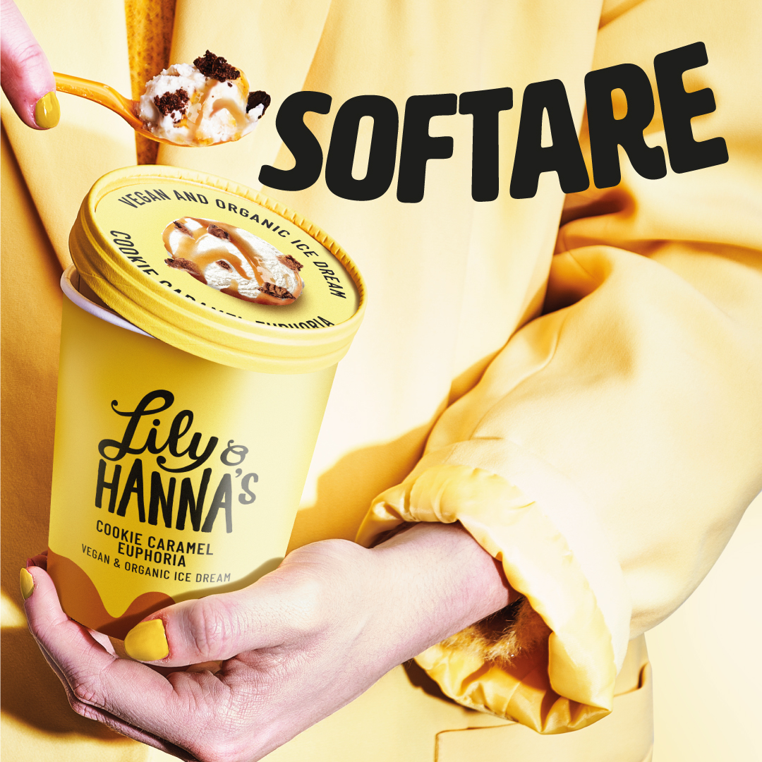 Produktfoto: Lily & Hanna's Kvinna i gula kläder som håller en gul glassbytta med en sked med glass i handen