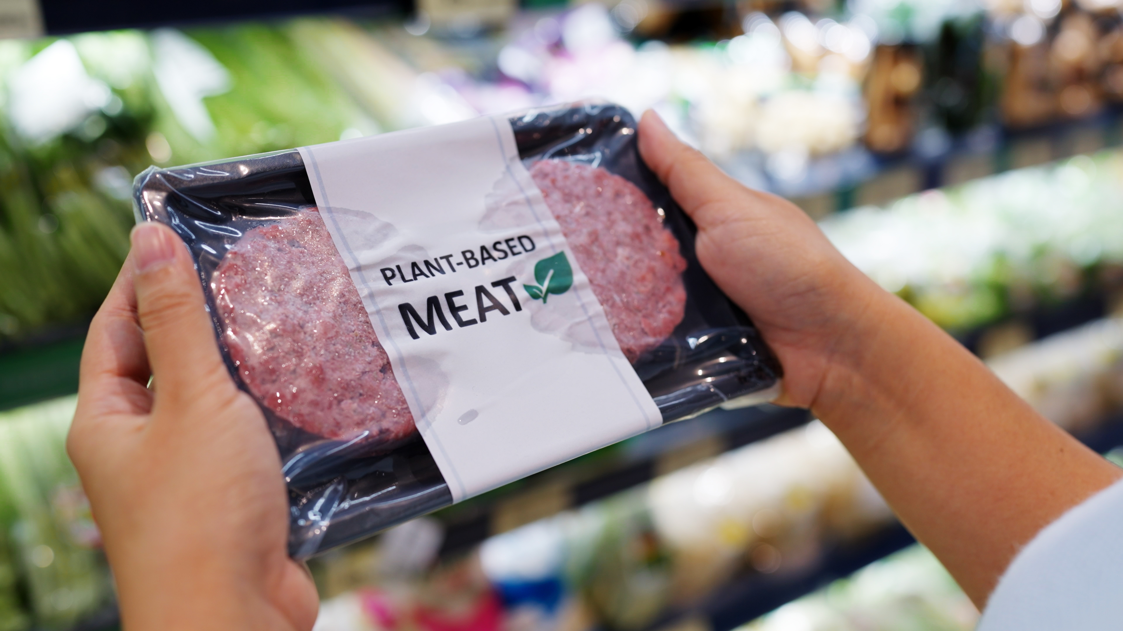 Foto: Chay_Tee/Shutterstock Händer som håller i en förpackning vegansk kött i en butik
