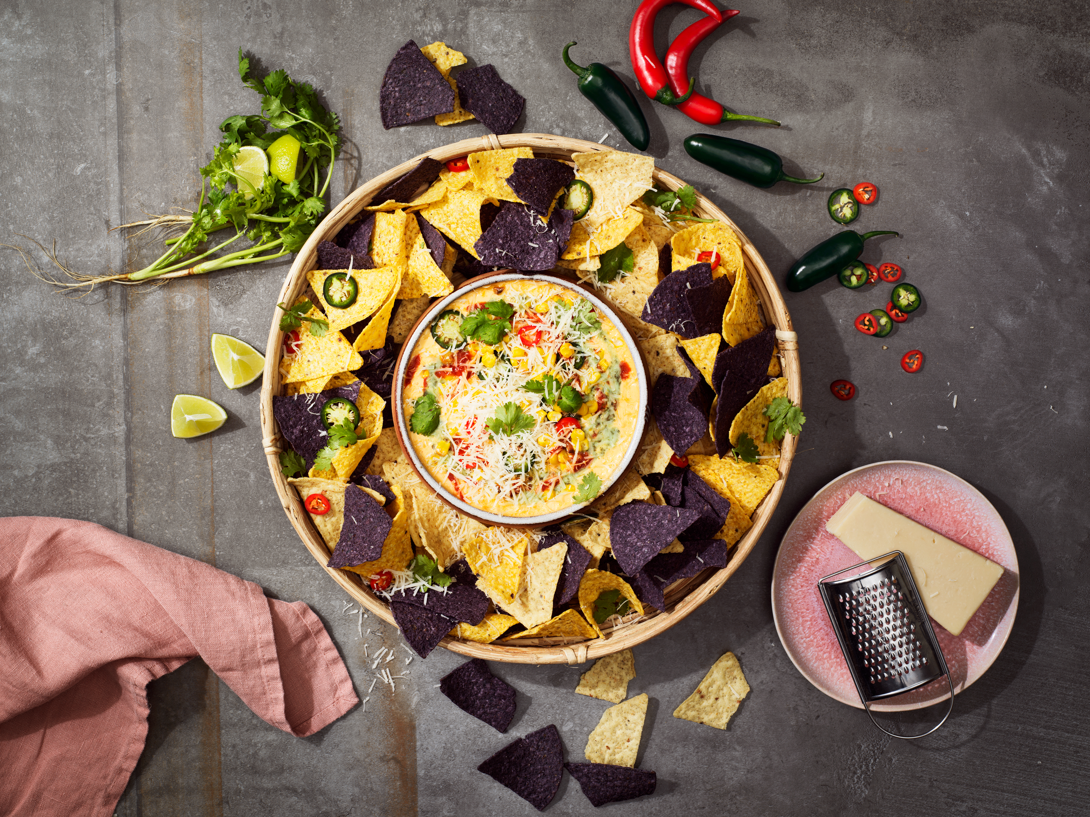 Produktfoto: El Taco Truck En skål med nachos och en liten skål med vegansk ostdipp mitt i den stora nachoskålen