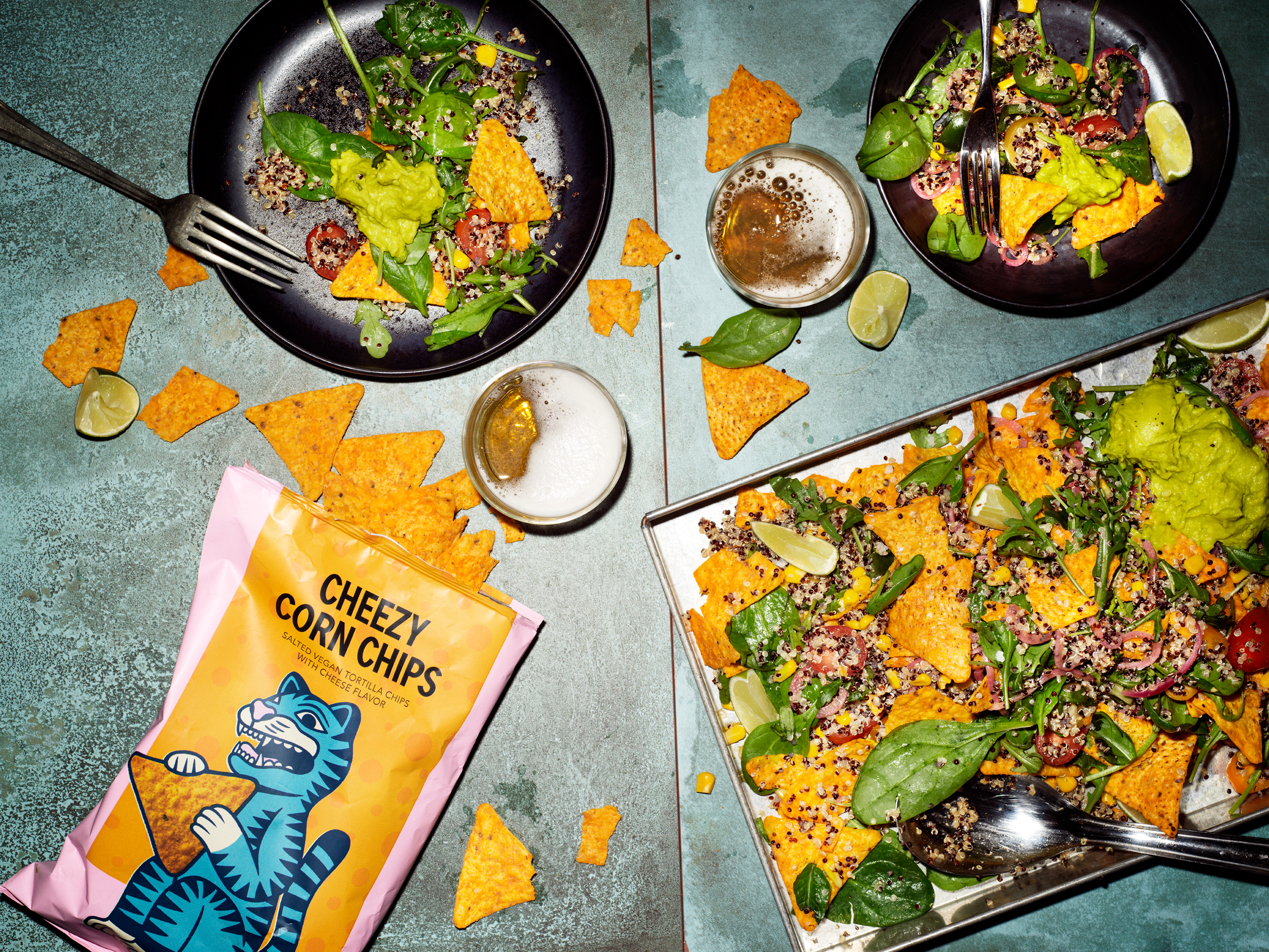 Produktfoto: El Taco Truck Ett plåtbord med tacorätter och en påse veganska nachos med ostsmak