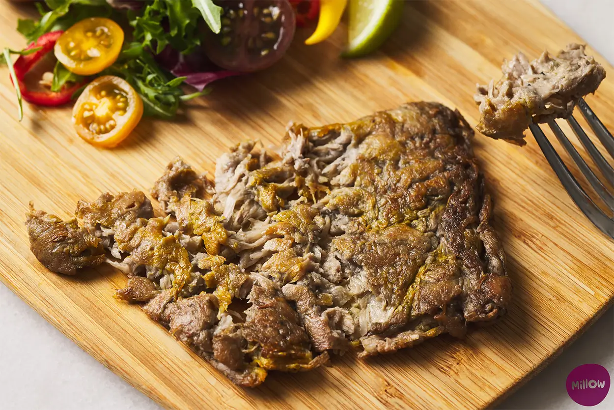 Produktfoto: Millow En vegansk file på svampprotein på en skärbräda i trä.