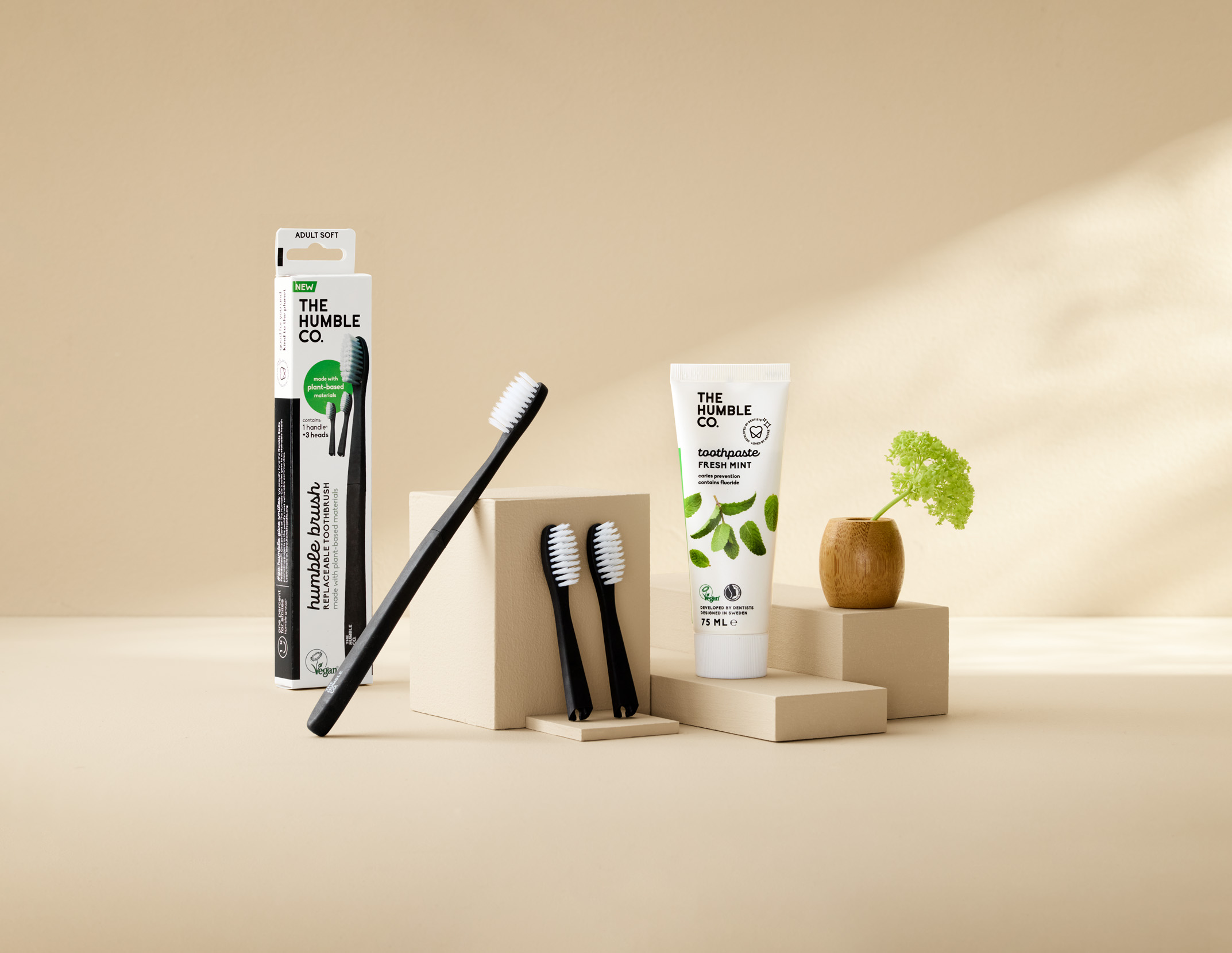 Produktfoto: The Humble Co Tandborstar och tandkrämer som är placerade mot en beige bakgrund