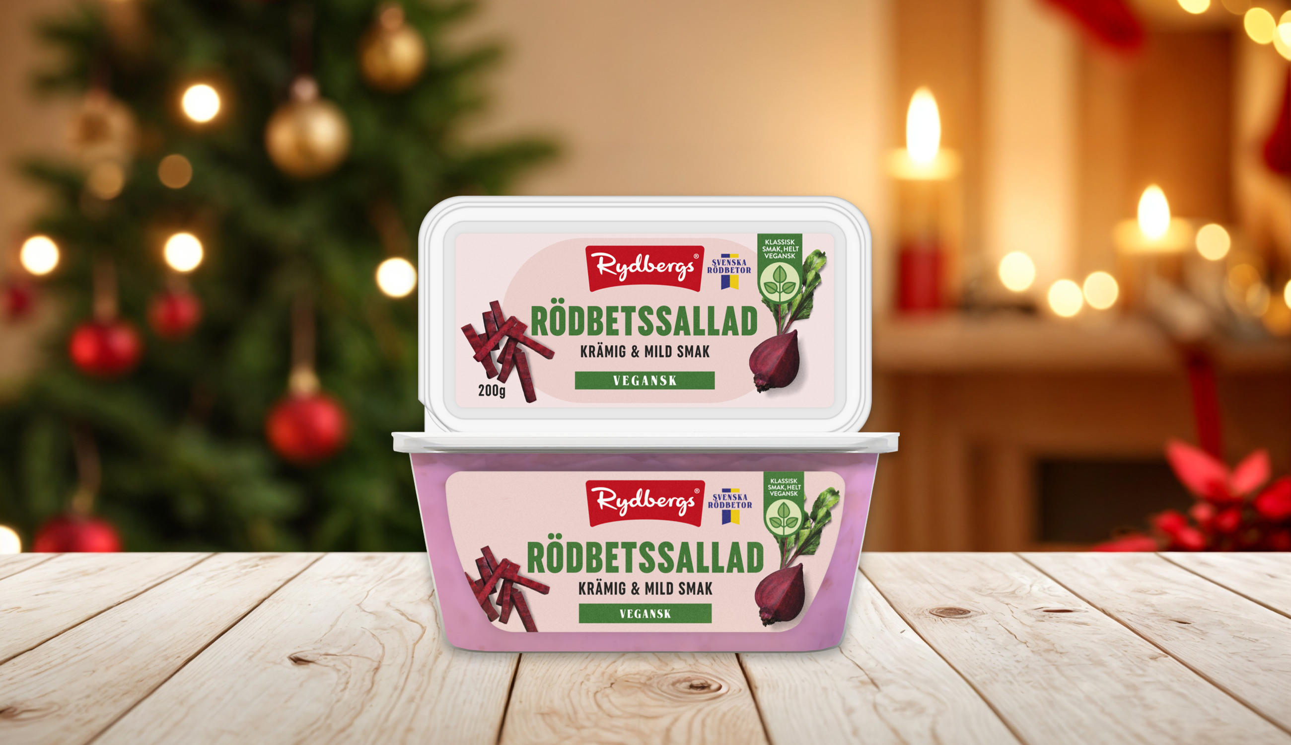 Produktfoto: Rydbergs två förpackningar vegansk rödbetssallad staplade på varanda på ett träbord med en julig bakgrund