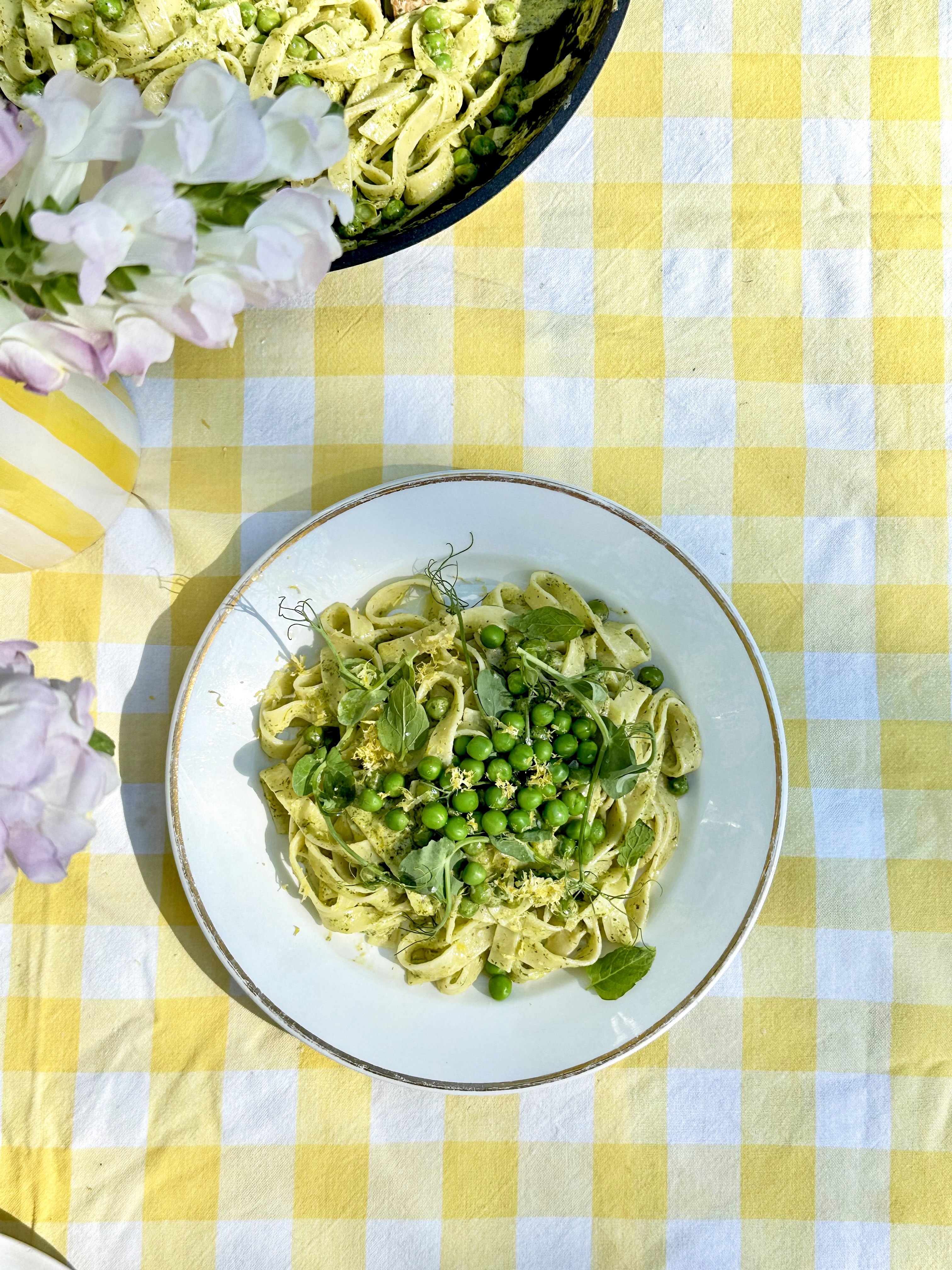 Foto: Apetit Tallrik med pasta och ärtor på en gulrutig duk