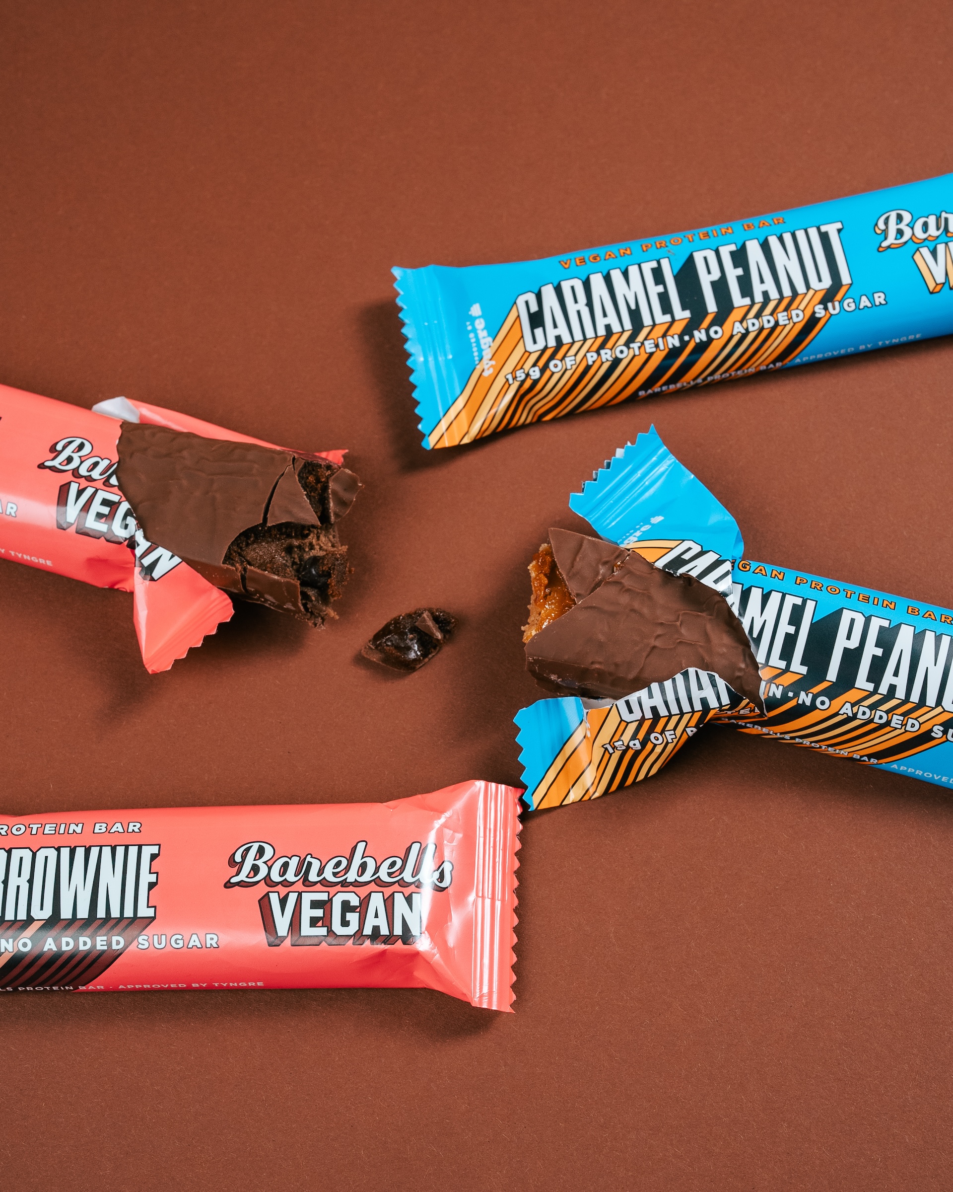 Produktfoto: Barebells Fyra veganska proteinbars på ett brunt bord
