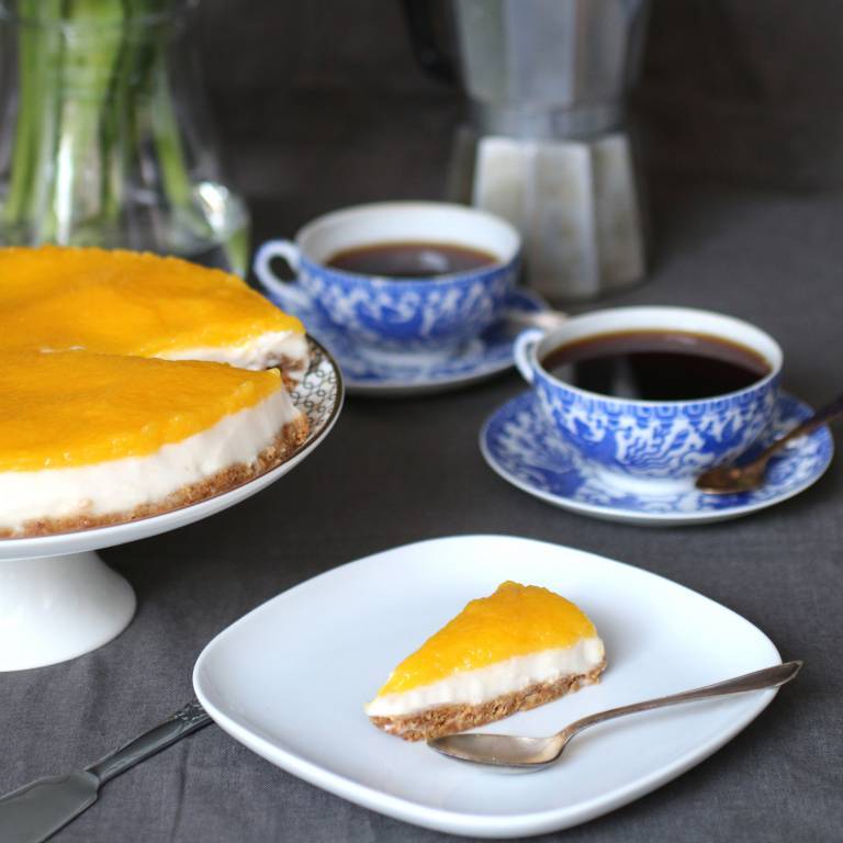 vegansk cheesecake med mangoglasyr på ett tårtfat