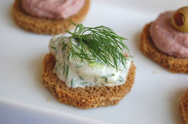 Vegansk sill med wasabi, på en liten skiva bröd, garnerad med dill.