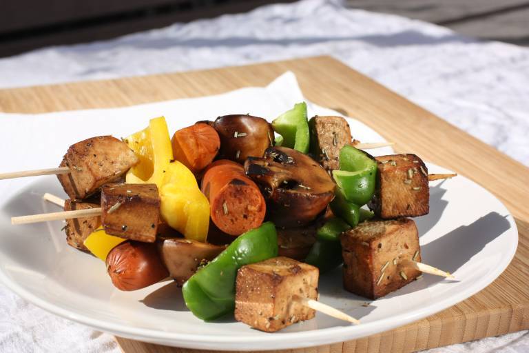 grillspett med tofu och grönsaker på en vit tallrick