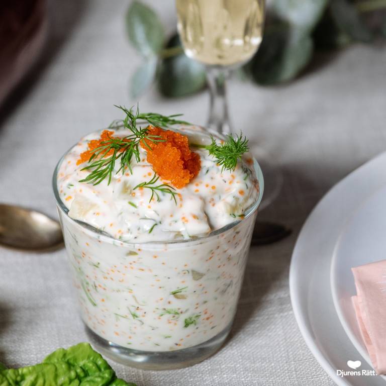 Vegansk skärgårdssill i ett glas på ett uppdukat bord. 