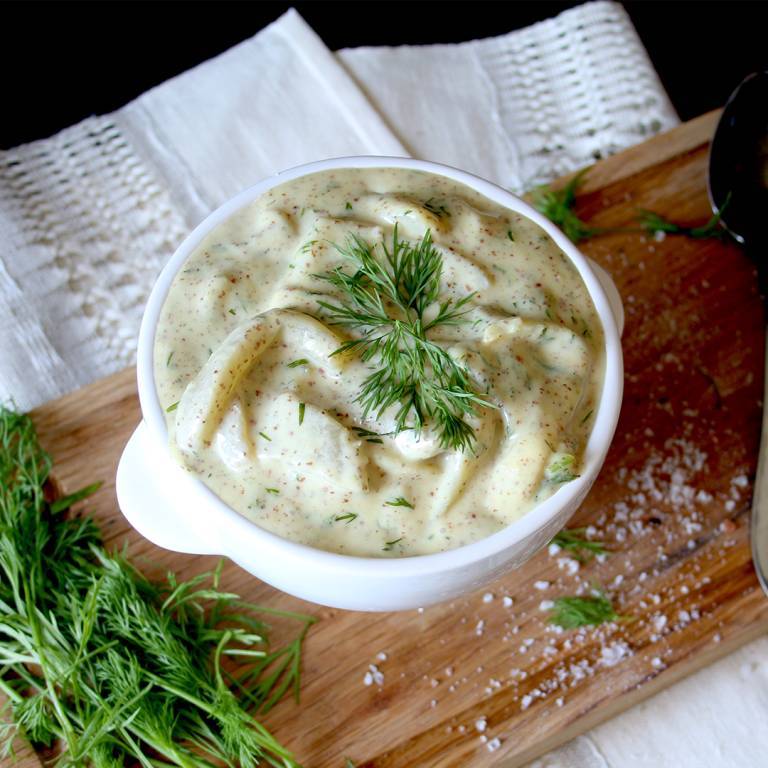 Vegansk auberginesill i en skål på en skärbräda i trä. 