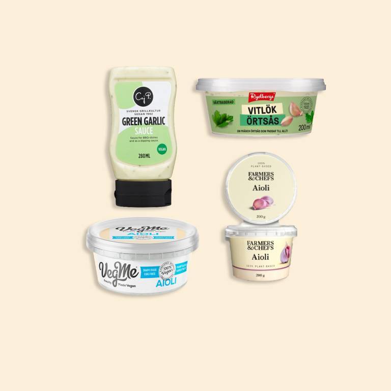 fyra förpackningar med vegansk vitlökssås mot en vit bakgrund