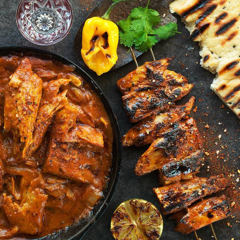 Vegansk Tikka Masala på ett spett bredvid en tallrik