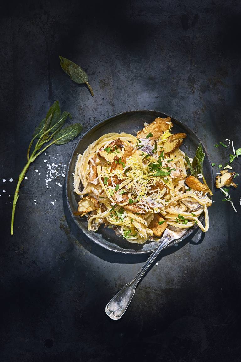 Vegansk kycklingpasta i en svart djuptallrik på ett svart bord