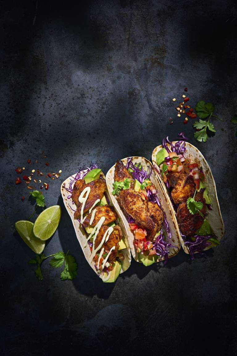 Tre mjuka tacos på ett svart bord