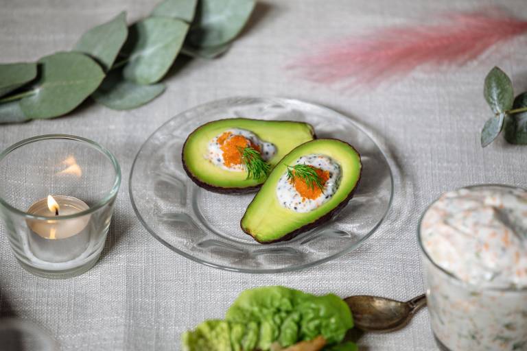 Avokadohalvor toppade med vegansk skagen och tångkaviar på ett glasfat