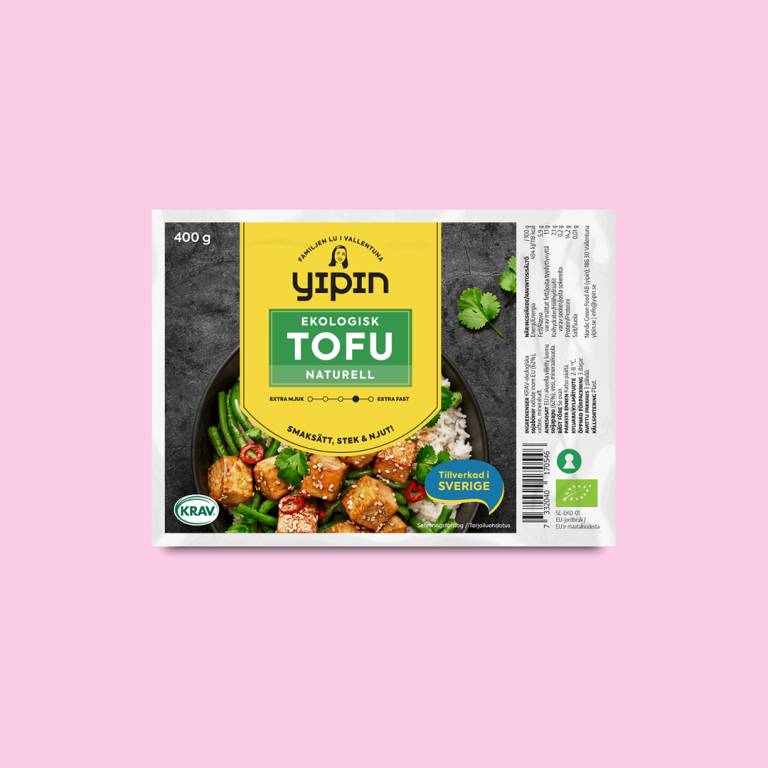 Ett paket tofu mot en ljusrosa bakgrund