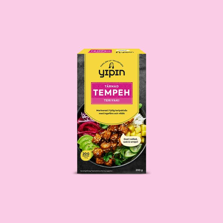 en förpackning tempeh mot en ljusrosa bakgrund