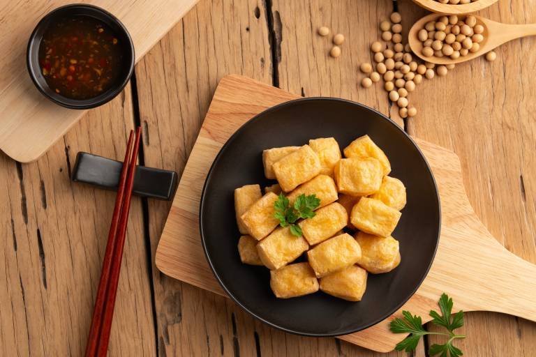 Friterad tofu i en tallrik på en skärbräda