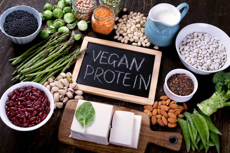Bild på svart skrivtavla med texten vegan protein, omringad av diverse grönsaker