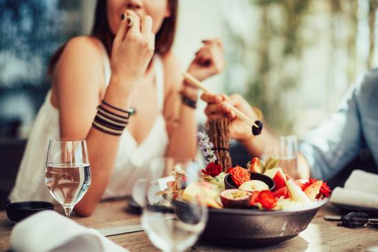 Personer sitter och äter en vegansk måltid tillsammans med andra