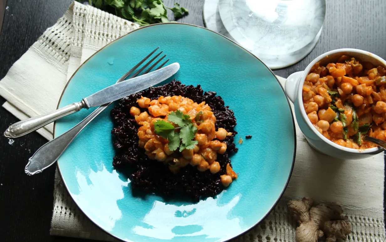 Kikärtscurry med svart ris på en turkos tallrik