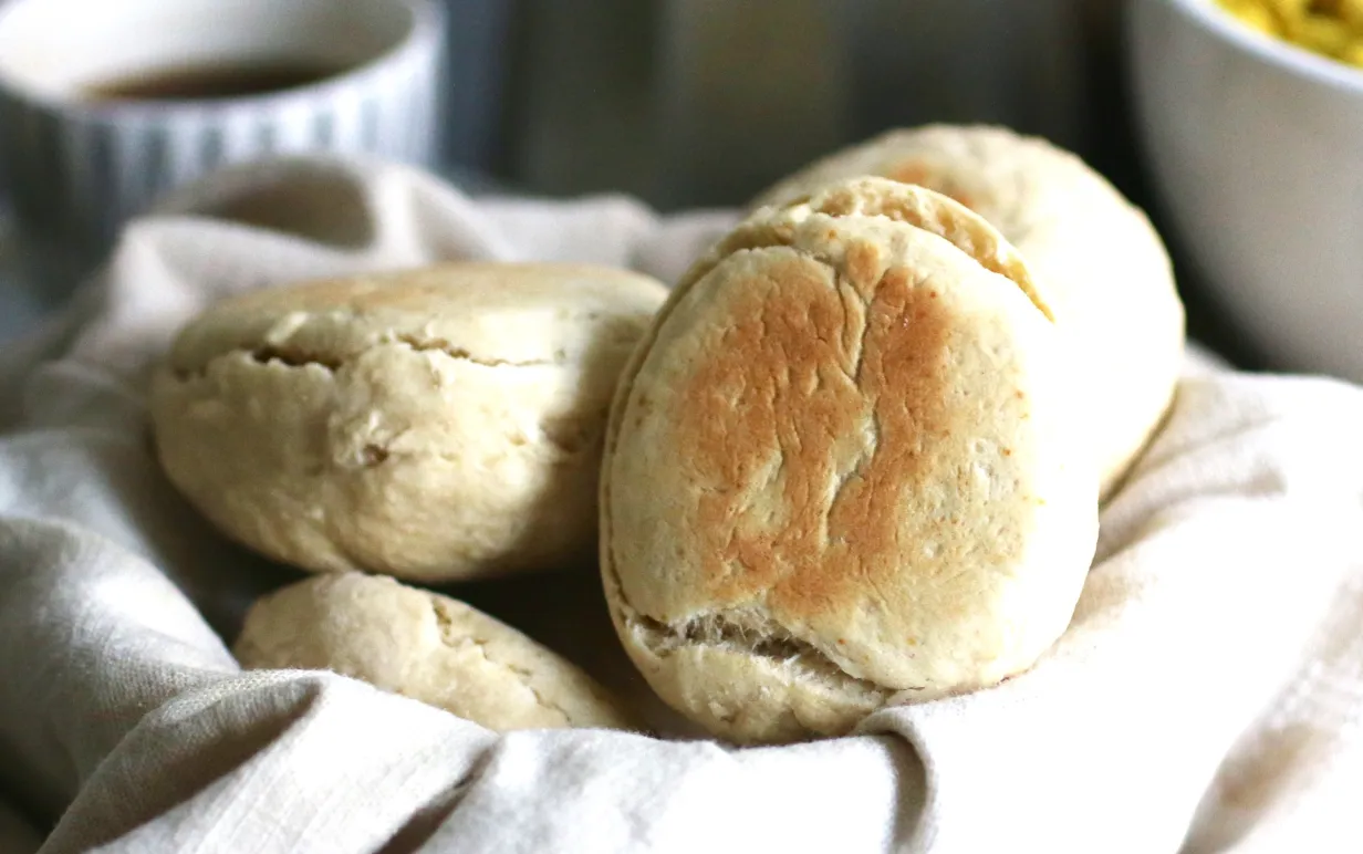 Scones i en korg, i bakgrunden syns en kopp kaffe.
