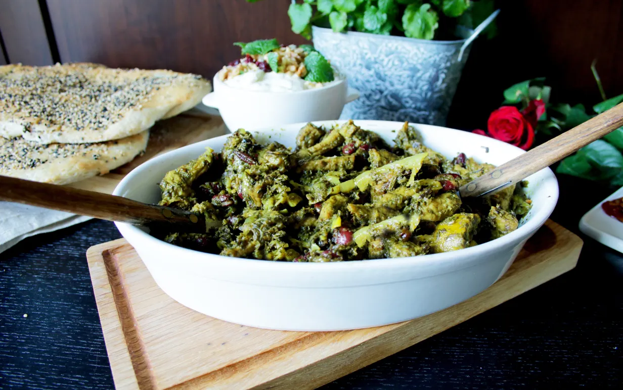 Ghorme sabzi i en vit form på en skärbräda